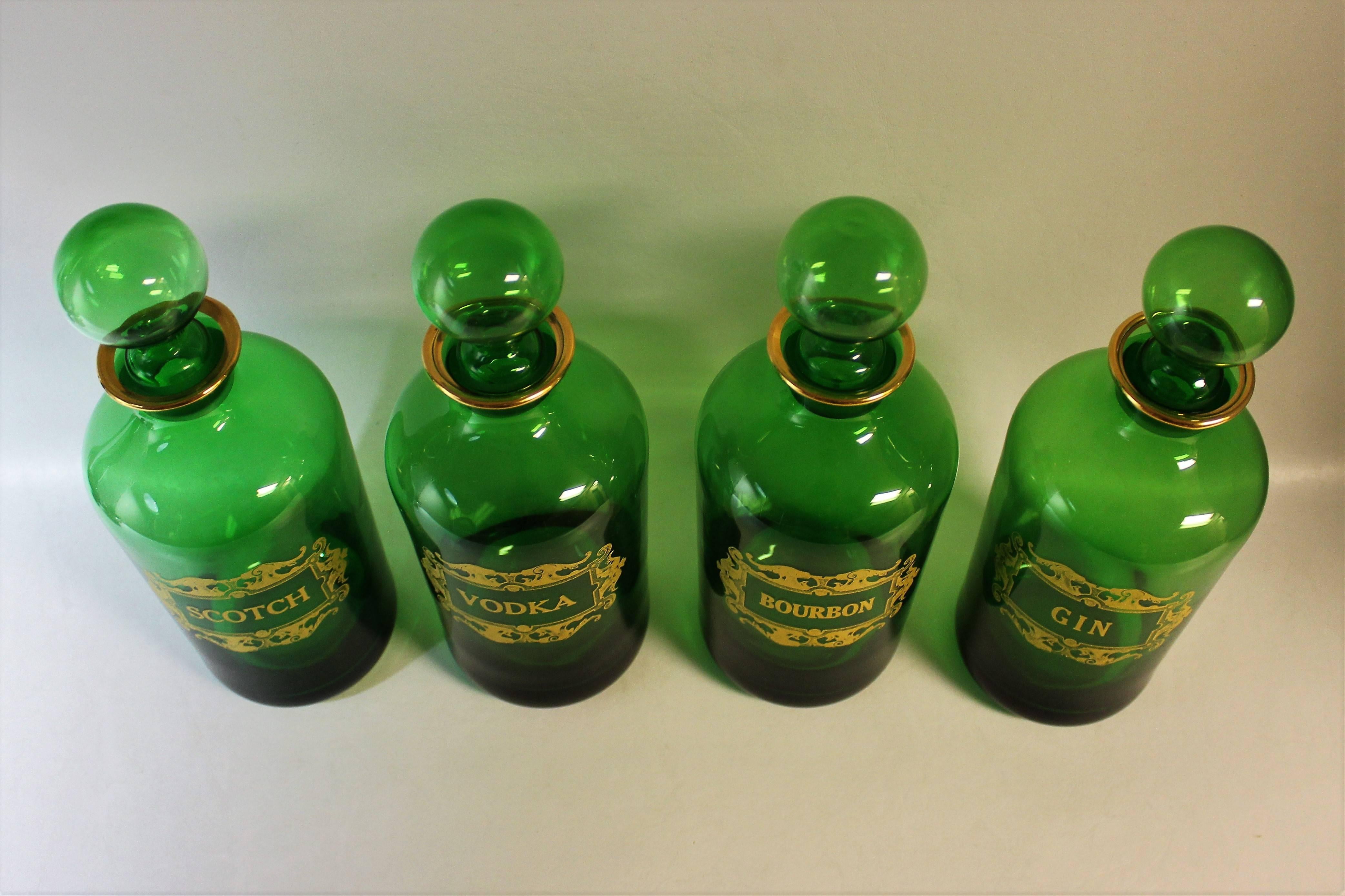 Set of four French glass gilt liquor decanter bottles: Scotch, Vodka, Bourbon, and Gin.