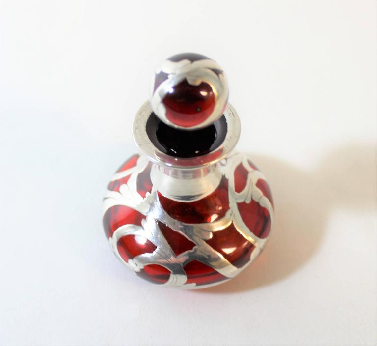 Ruby glass Art Nouveau perfume bottle with silver overlay.