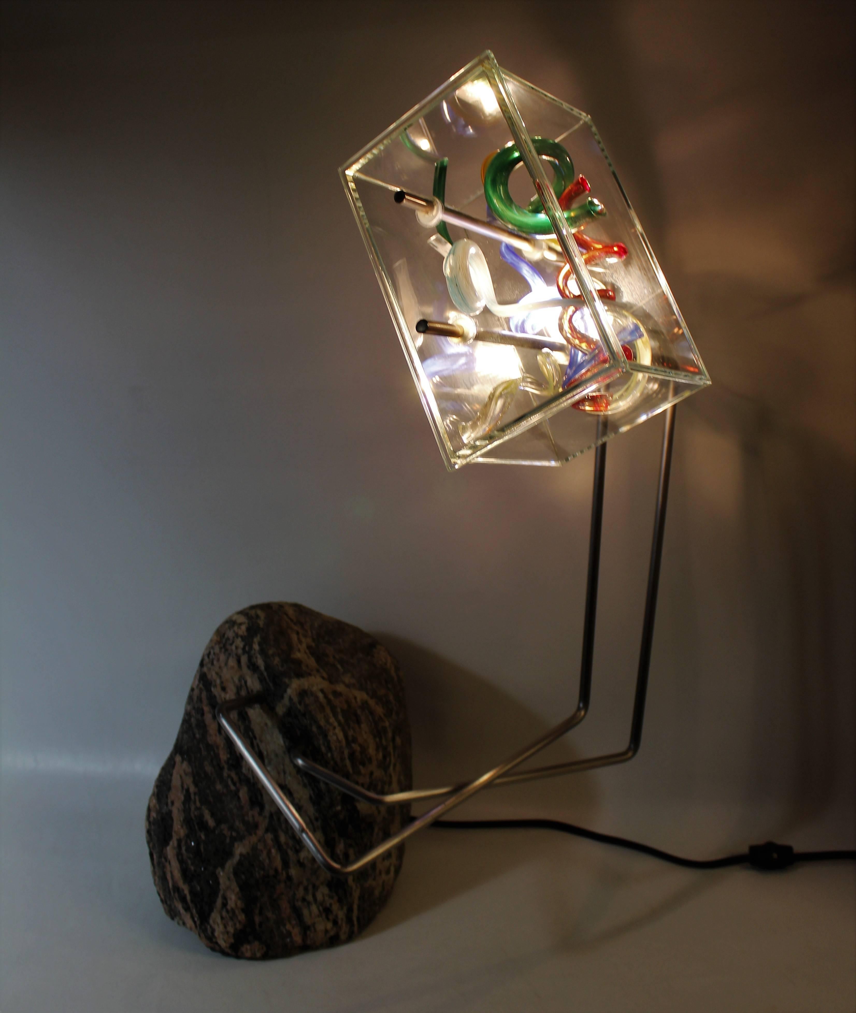 Beautiful lamp made by Daniel-Jean Primeau. It's made of handblown colored glass spirals encased in a clear cut-glass cube. The base is made of solid granite with brushed stainless steel tubes protruding out. Beyond the remarkable object itself,