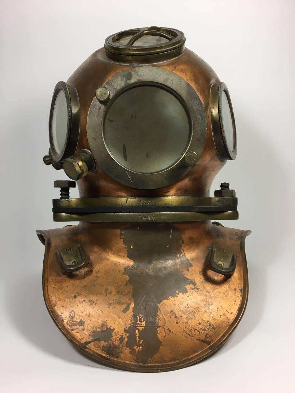 A mid-20th century diving helmet from the Draeger Company of West Germany, they are still among the world leaders in diving apparatus, and other fields requiring respiration devices. It has the top-mounted carrying handle that Draeger added to their
