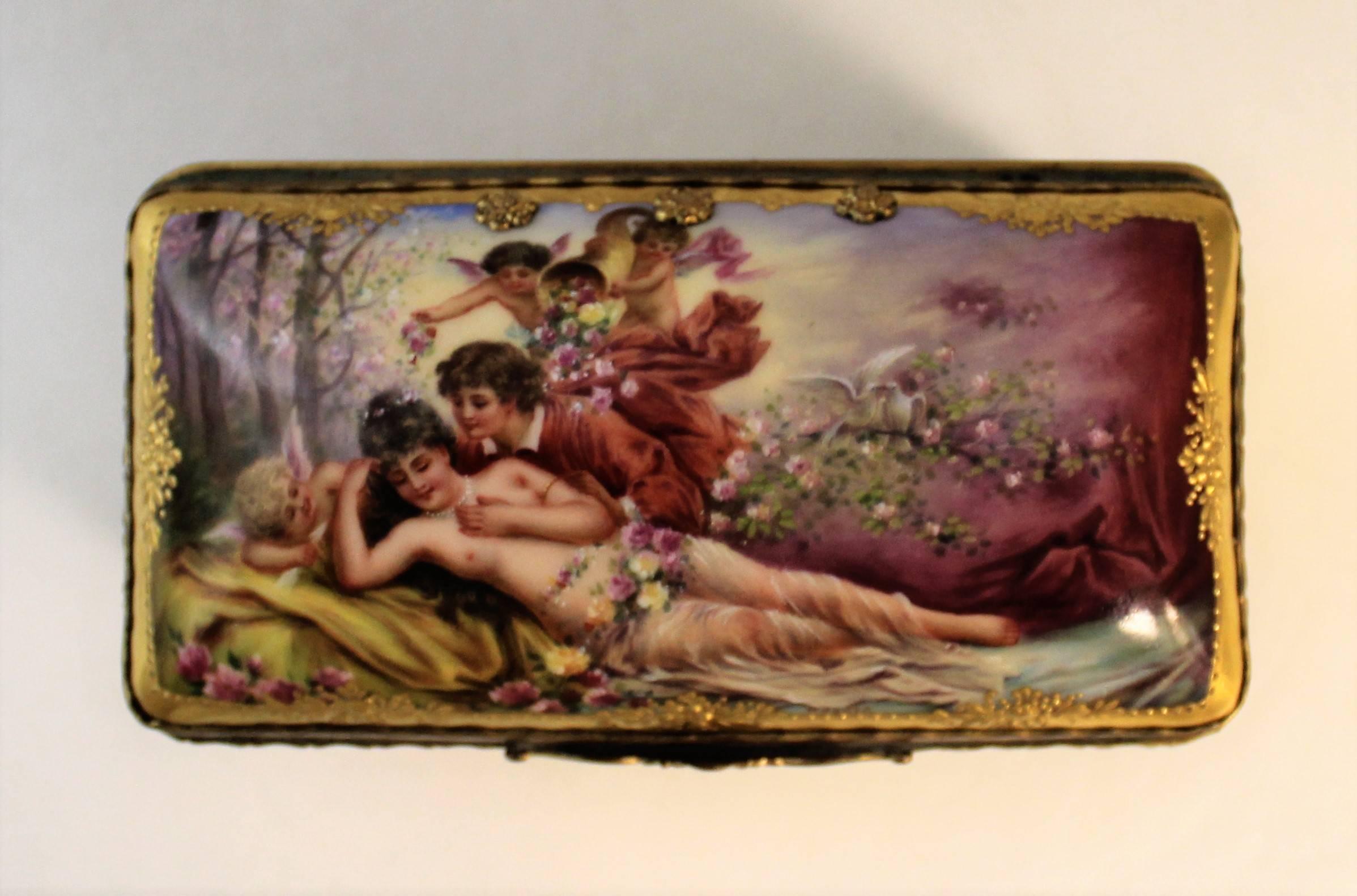 Porcelain box signed 'Wagner' with elaborate jewelled gilding and hand-painted romantic scene.