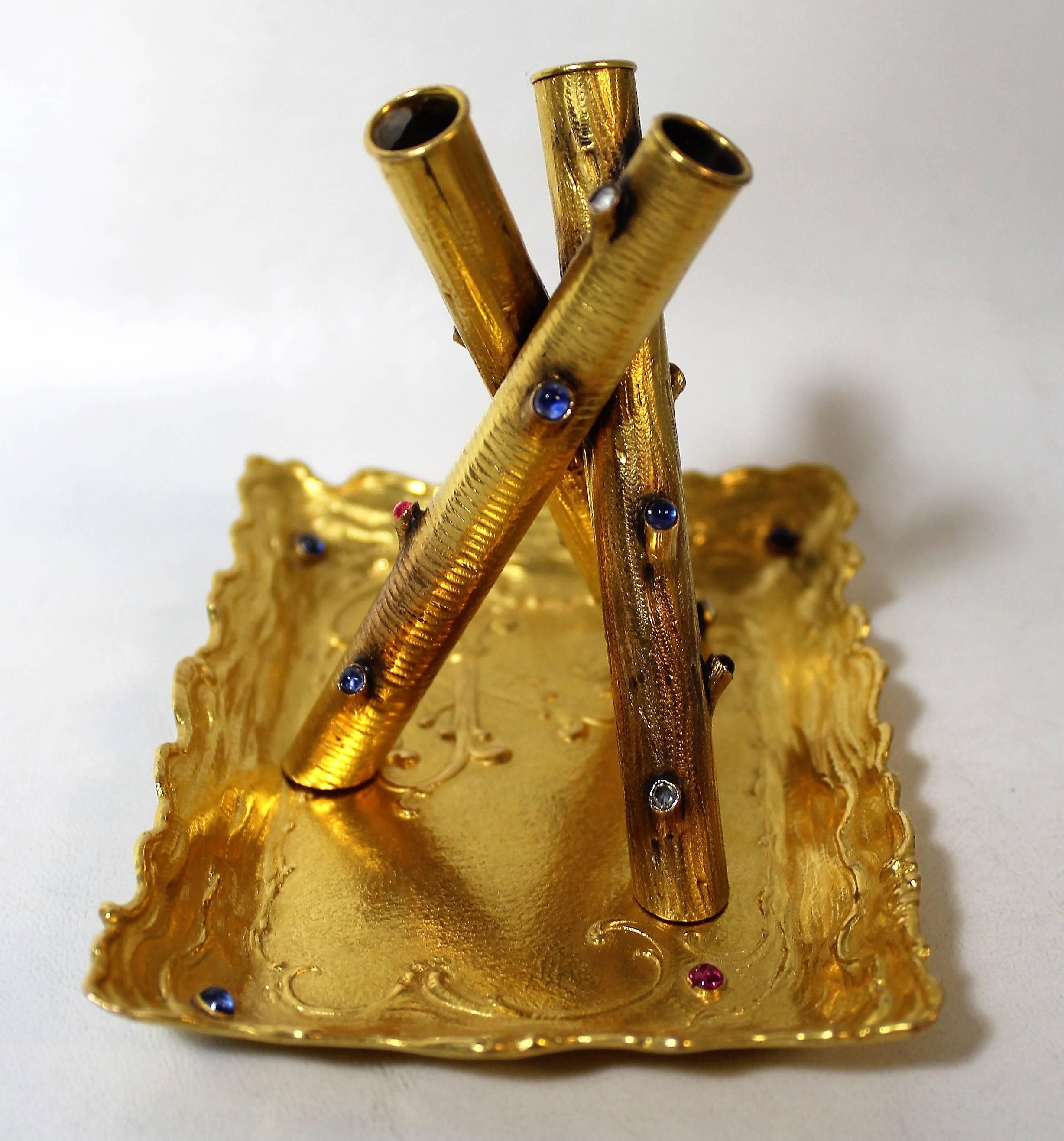 Magnificent 14-karat gold pen holder and tray with diamonds, rubies and sapphires.
Pen holder
Handmade tubular pen holder in fourteen karat yellow gold with a tripod design. It is set with four rose cut diamonds of 2.6 m.m. in diameter. It is also