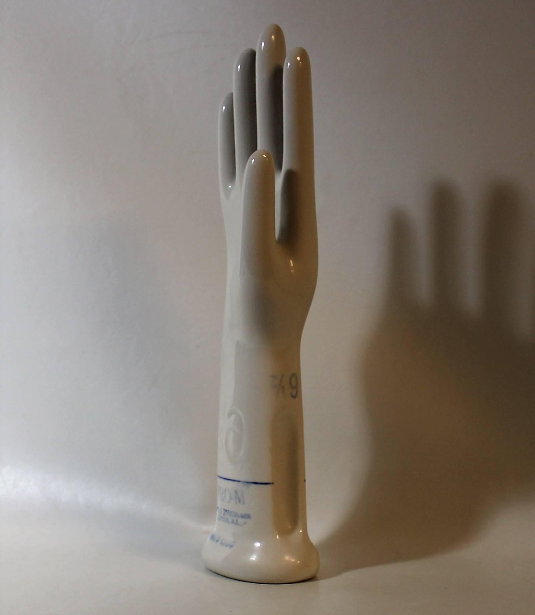 Industrial porcelain handmade to mold a size 6.5 glove. It's made of smooth white porcelain marked with blue lines and print. This unit would be a great display for jewelry or an interesting Industrial style sculpture for any room with an eclectic