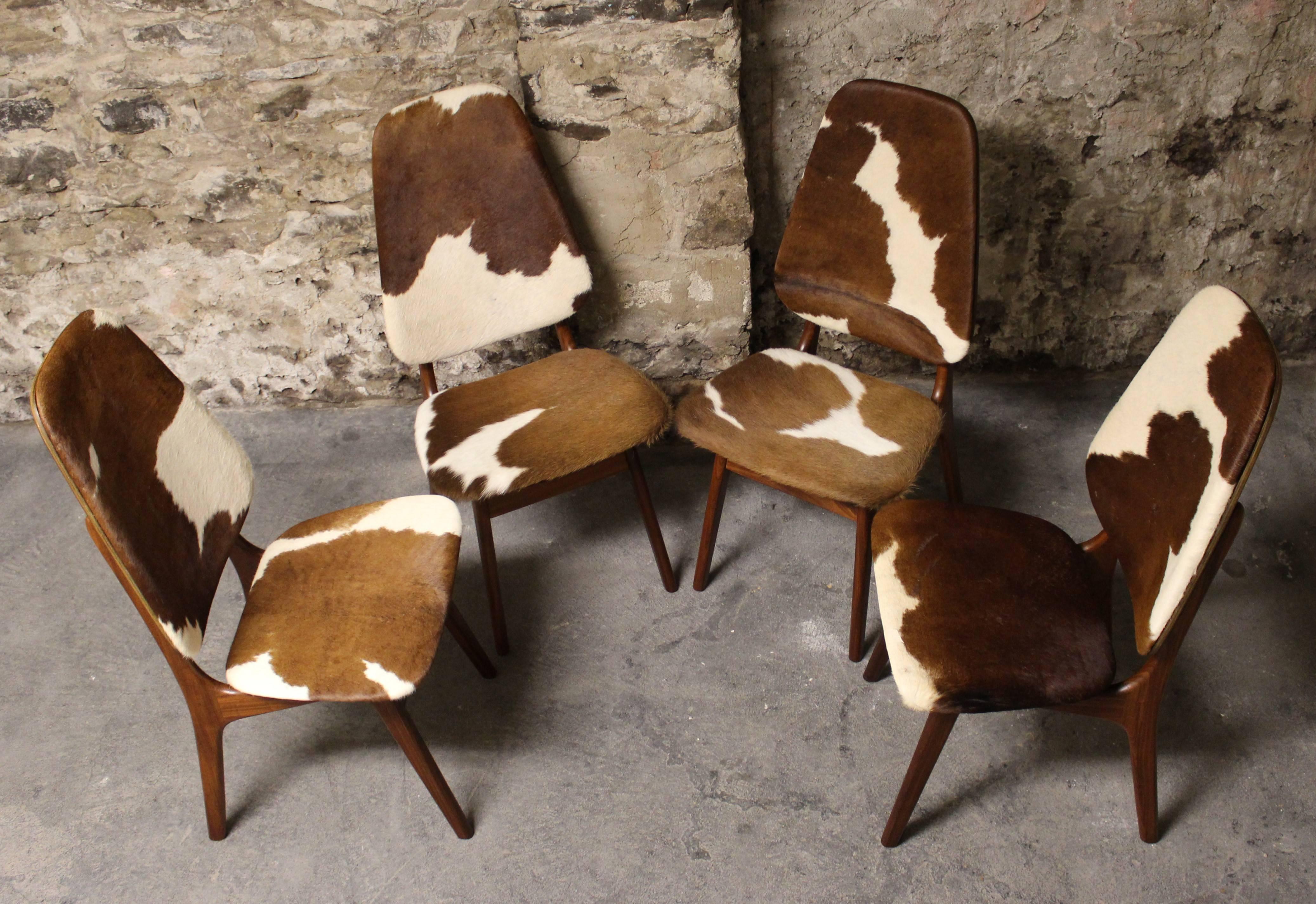 Four Arne Hovmand Olsen Danish teak high back dining chairs in newly upholstered cowhide.

Scandinavian Modern/Mid-Century Modern.