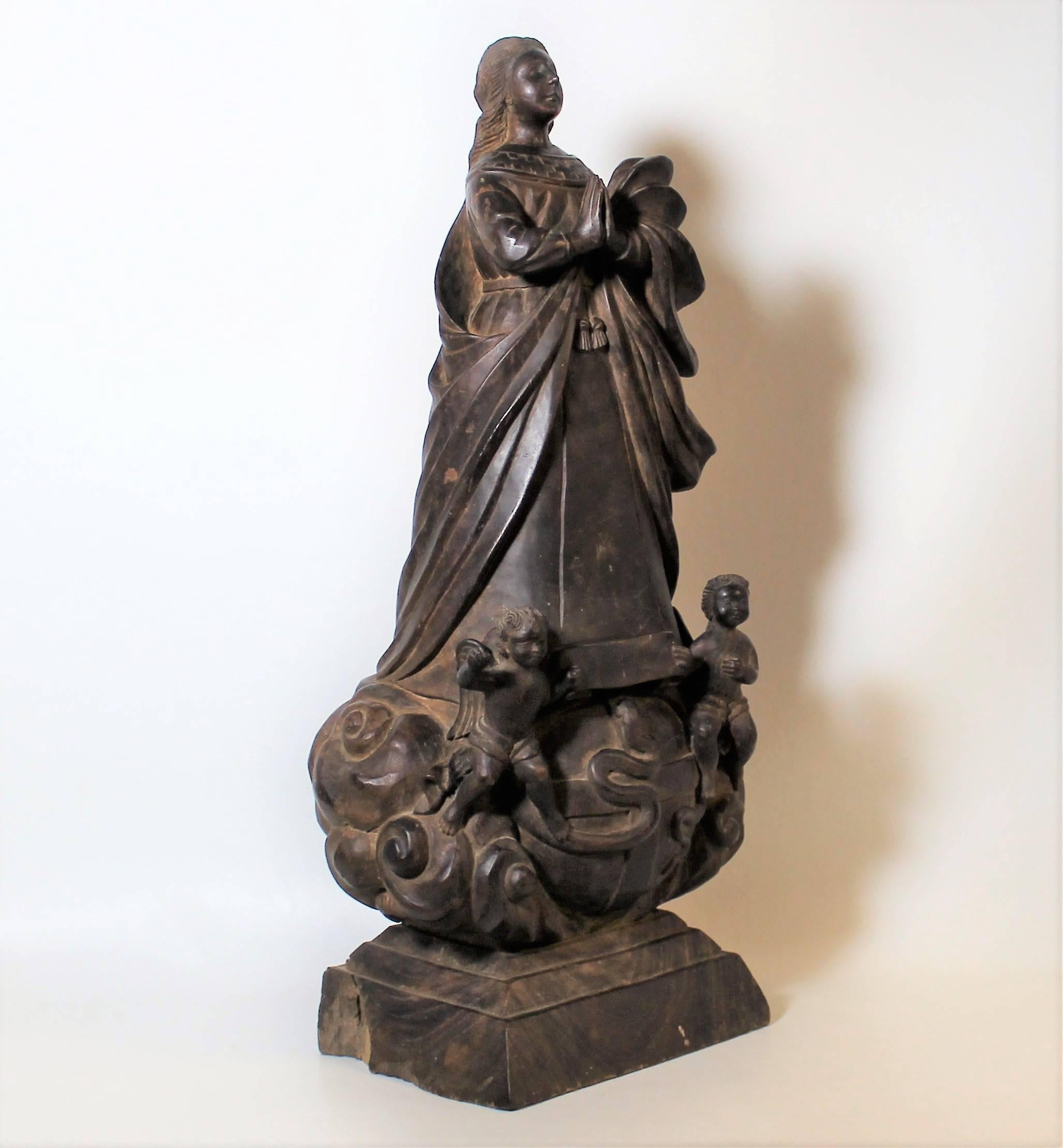 17th Century wood carving of the Virgin of the Immaculate Conception. This sculpture features the Virgin Mary atop the world with a serpent and angels at her feet.