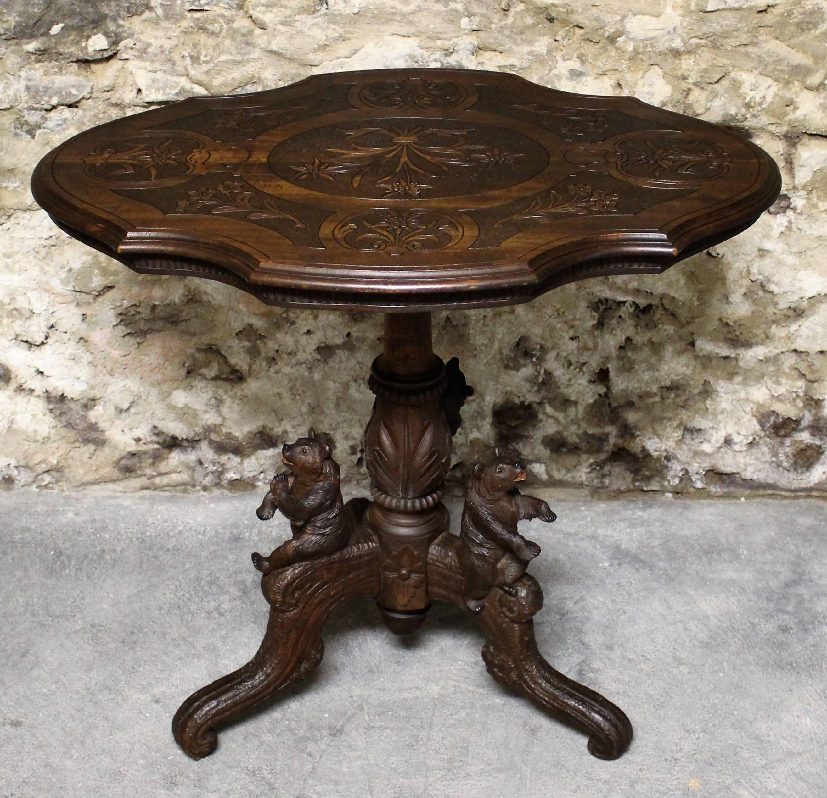 Very stylish Black Forest side table, circa 1890. The table legs are topped with three realistically carved bears while the tabletop features scrolling foliate open fretwork.