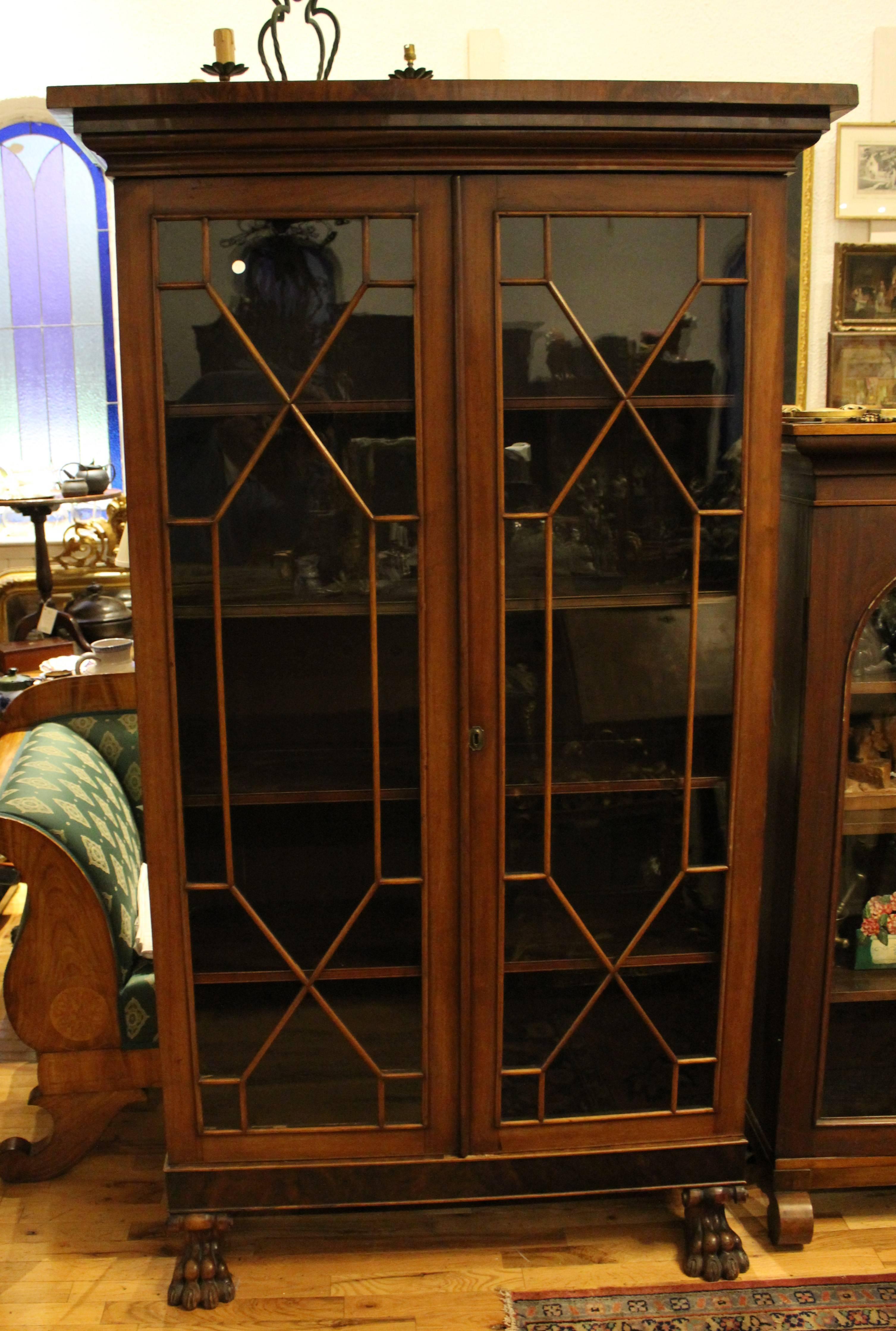Regency mahogany display cabinet with original finish, adjustable shelves and claw feet.