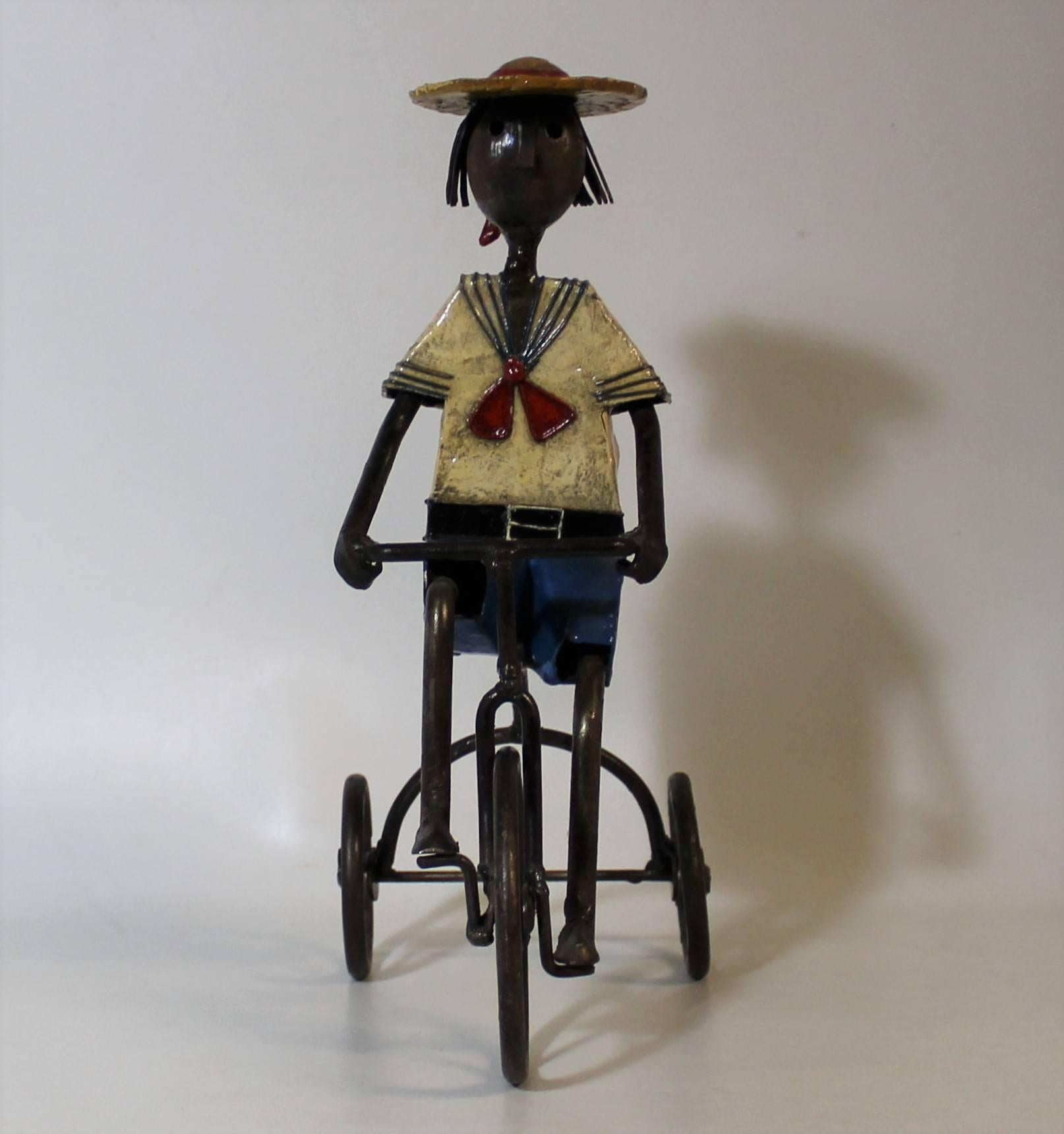 Whimsical metal and papier mâché sculpture of a boy on a tricycle by Mexican artist Manuel Felguerez.