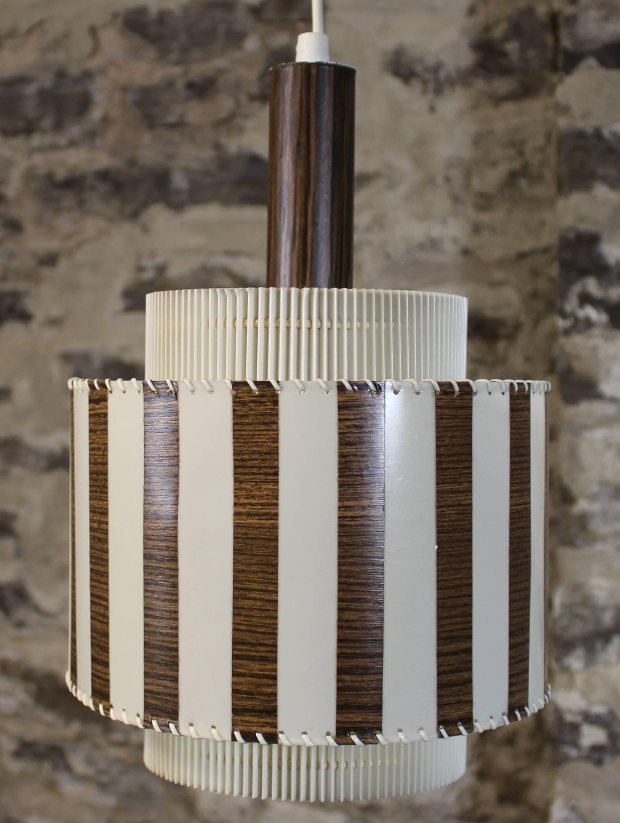 Mid-Century Modern light fixture or pendant.

Unique design done in accordion pleated plastic with white and wood effect stripes.

Free shipping within the United States and Canada.