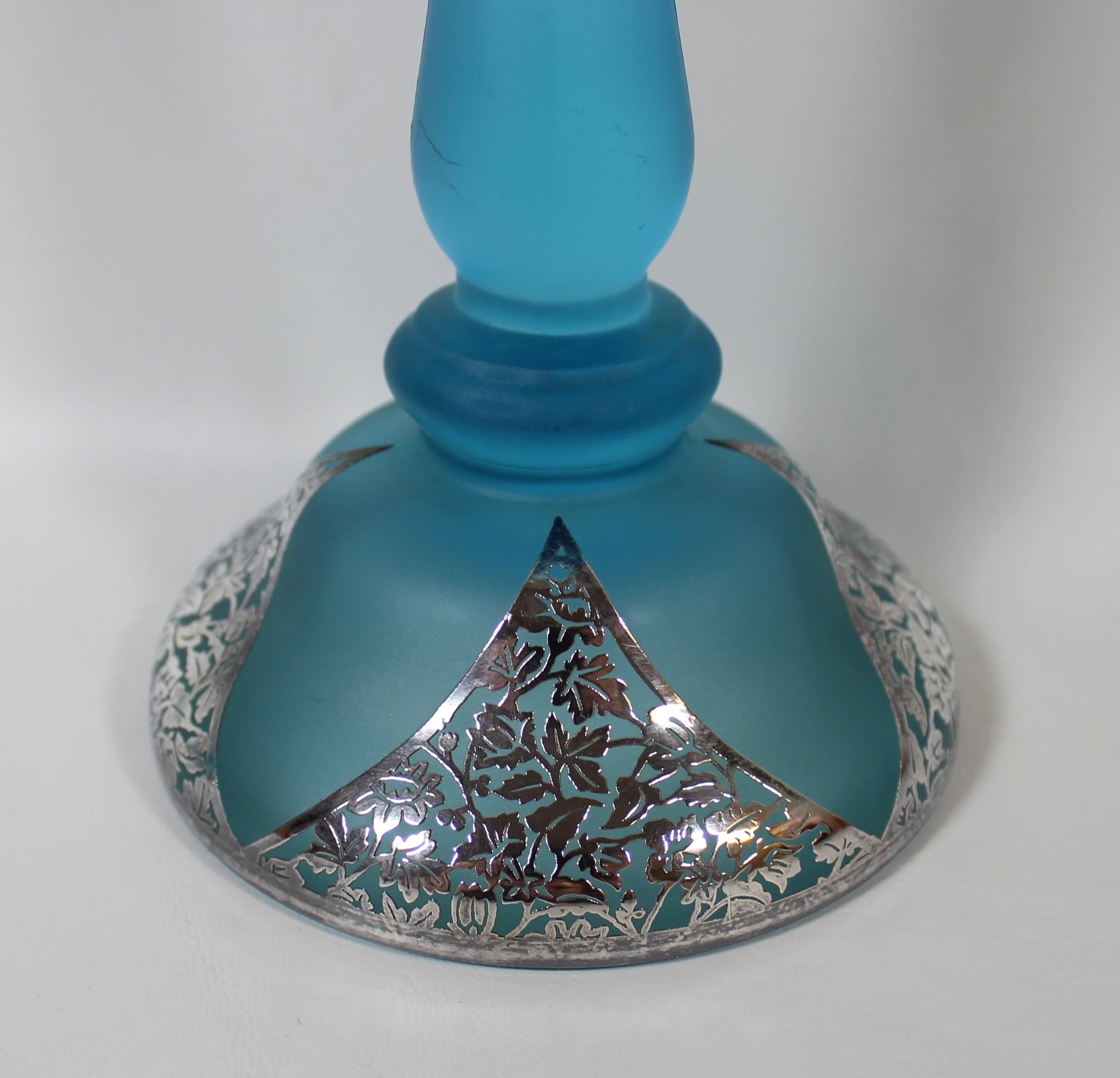 Pair of Art Nouveau Electric Blue Candlesticks with Silver Overlay 

Dramatic pair of opulent Orientalist style electric blue satin glass candle holders  with elegant silver overlay triangular cabuchons at base and silver overlay rims at