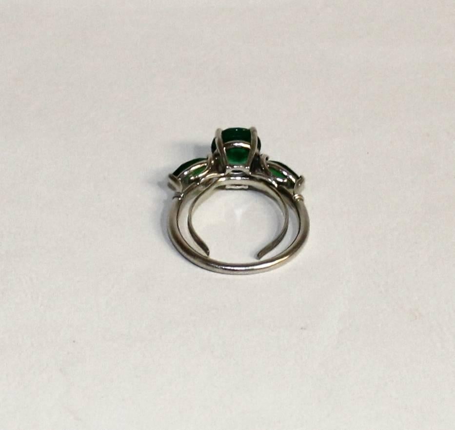 Ladies platinum ring set with synthetic emeralds.

Ring is set with one 7mm round good colour emerald. Also set with two small 6mm marquis cut emeralds. All the stones are claw set. It has a ring guard on it as you can see in the pictures so the