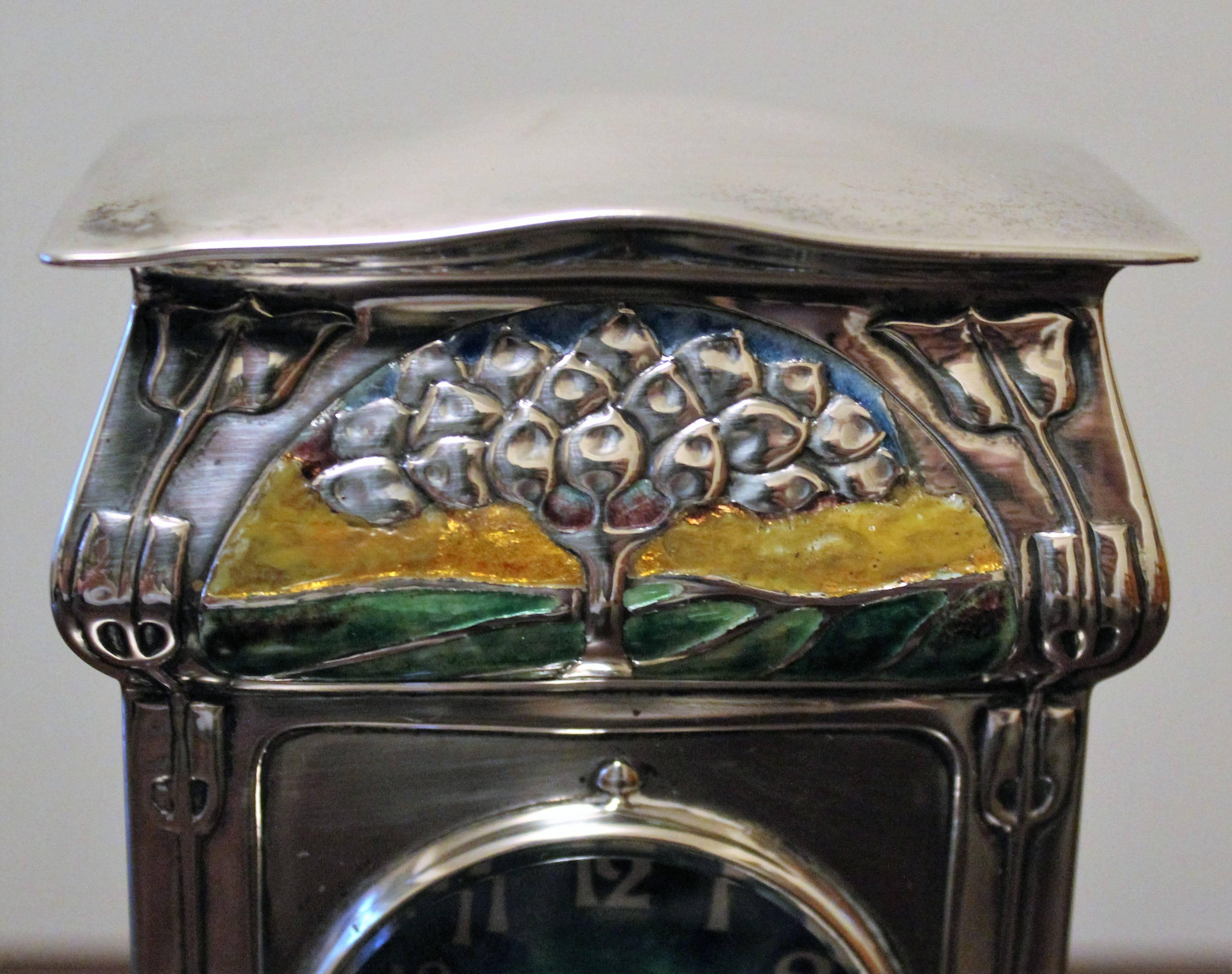 David Veasey for Liberty & Co. 'Cymric' Silver and Enamel Mantel Clock

This extremely rare clock features a single train movement with a circular  enamel dial. The case features flared bracket feet,  stylised plant forms and a polychrome enamel