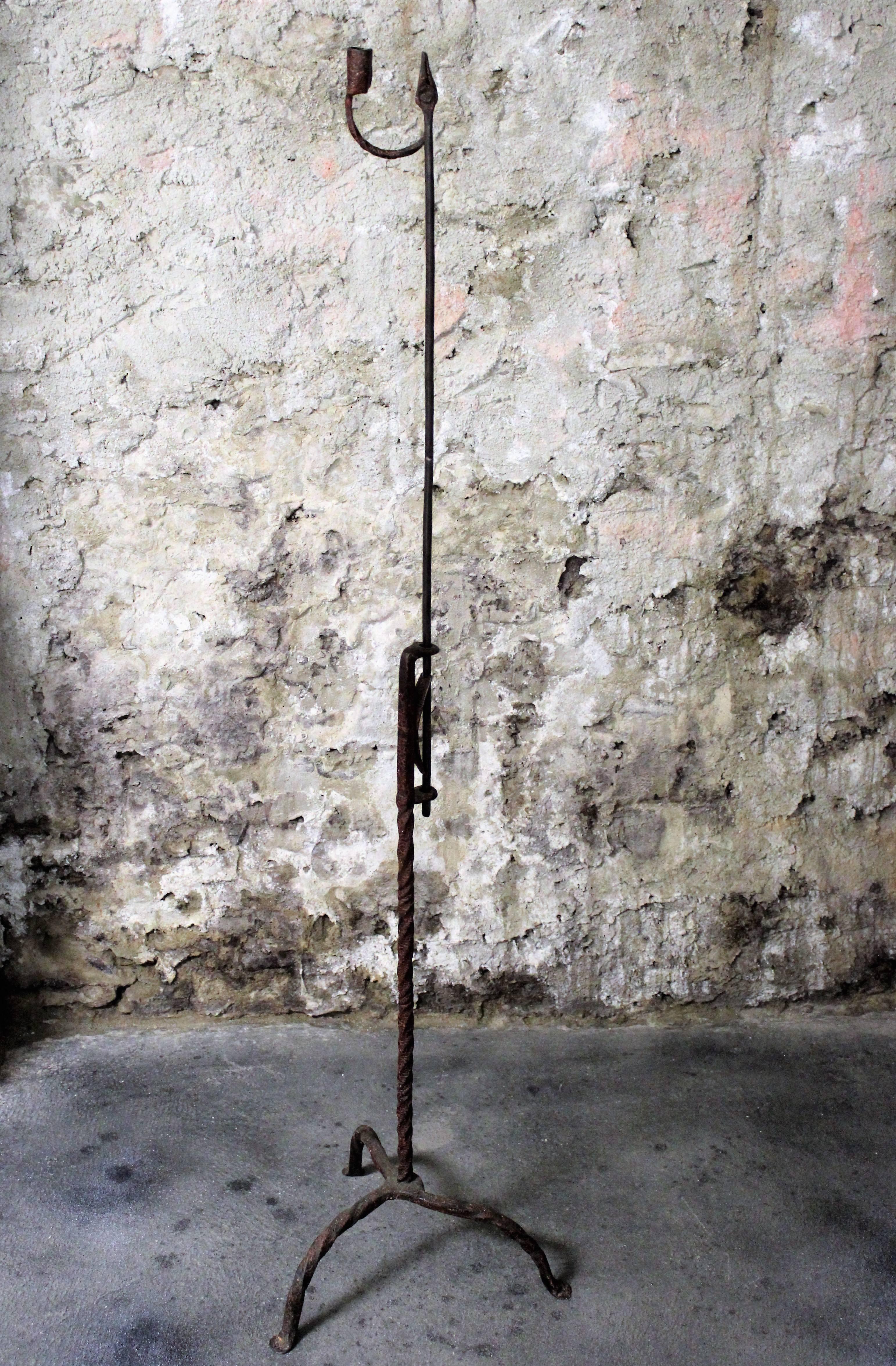 A fine example of an 18th century adjustable floor standing rush light with twisted stem and legs terminating in penny feet. Contains remnants of beautiful and original crackled paint throughout.

Rush lights or rush lamps are an old form of