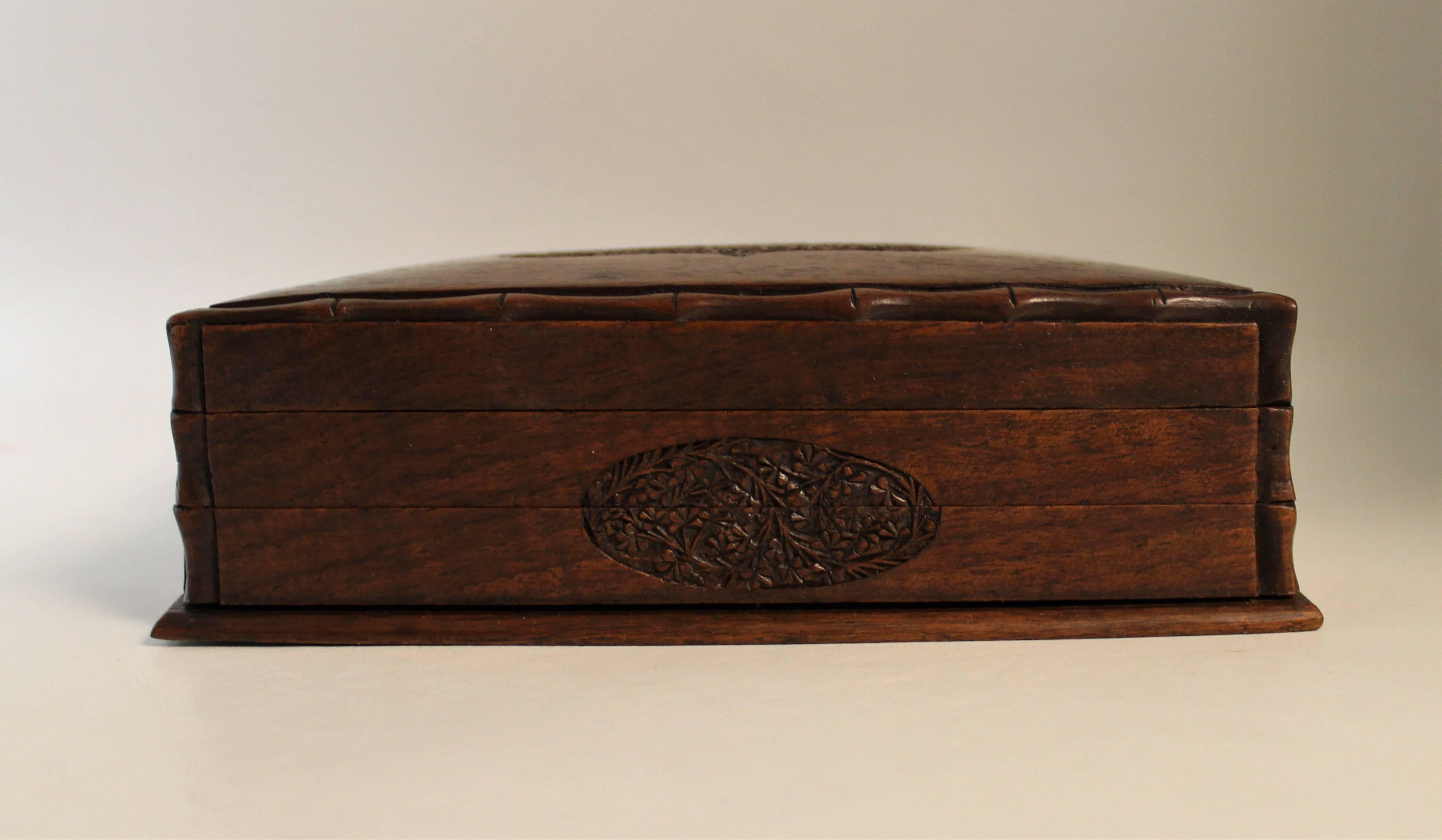 Edwardian hand-carved box with a trick opening. The box was designed as a table box for cigars, cigarettes or games It also features a trick way of opening it in which you have to slide a strip across on the front of the box.