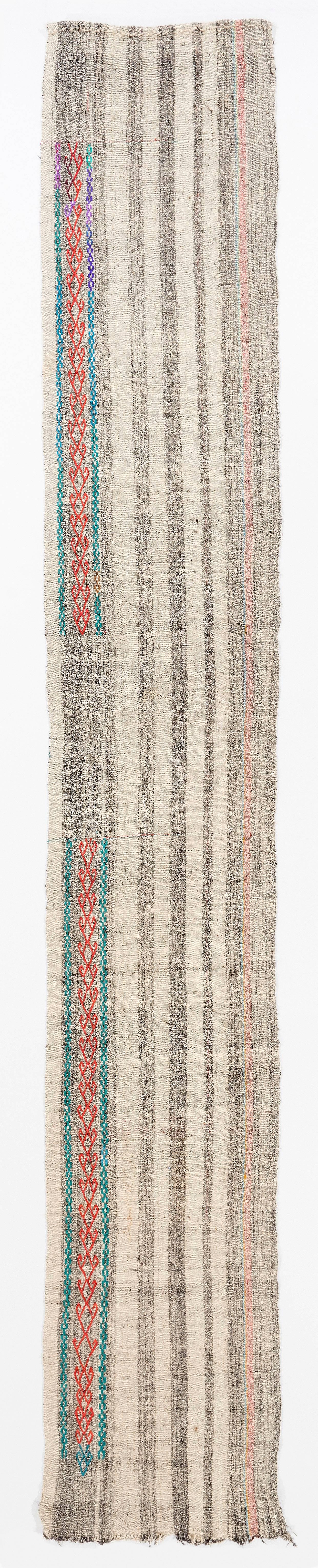 A simple yet beautiful wool flat-weave runner rug made of cotton and goat's hair, handwoven by the nomadic tribes in South Central Turkey. It features a banded design in dark brown and off-white with a touch of dark orange as well as a decorative