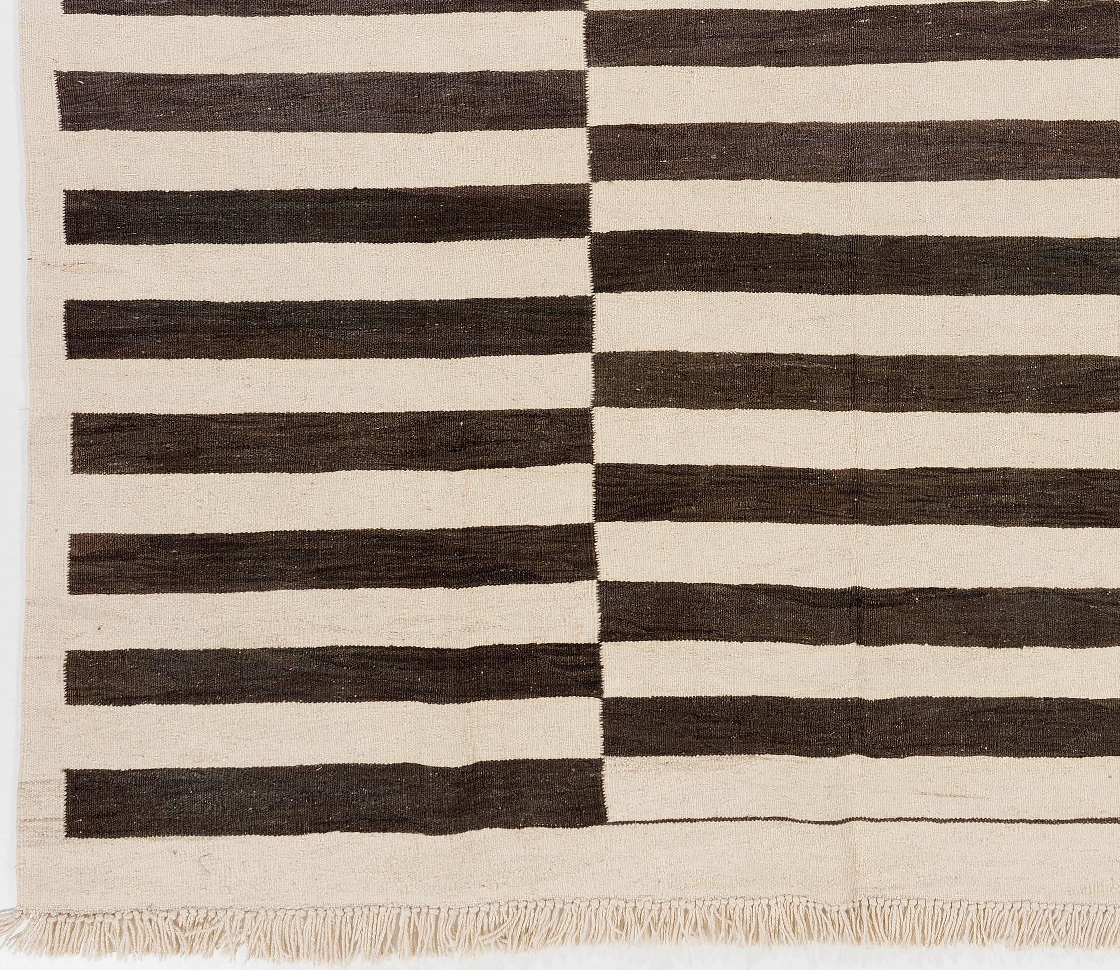 A flat-weave Kilim rug from Turkey made of natural undyed sheep wool in black and cream colors. Sturdy and ideal for both residential and commercial interiors. 

An identical rug can be re-produced in any size and color combination requested.