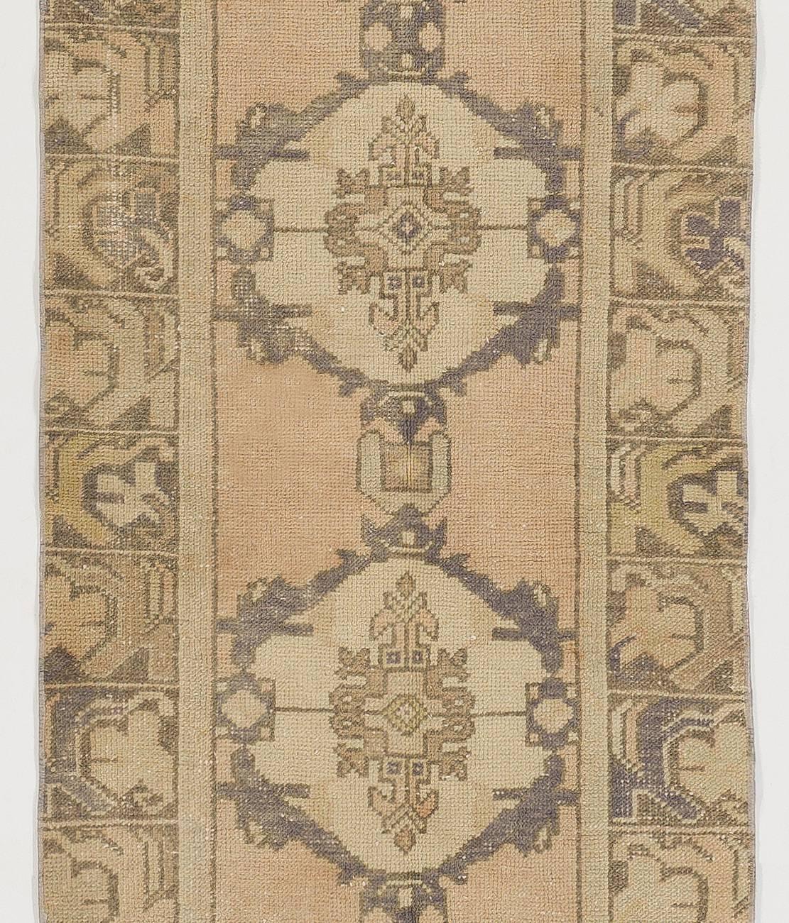 A midcentury hand-knotted village rug from Central Turkey with soft medium wool pile and washed out colors.