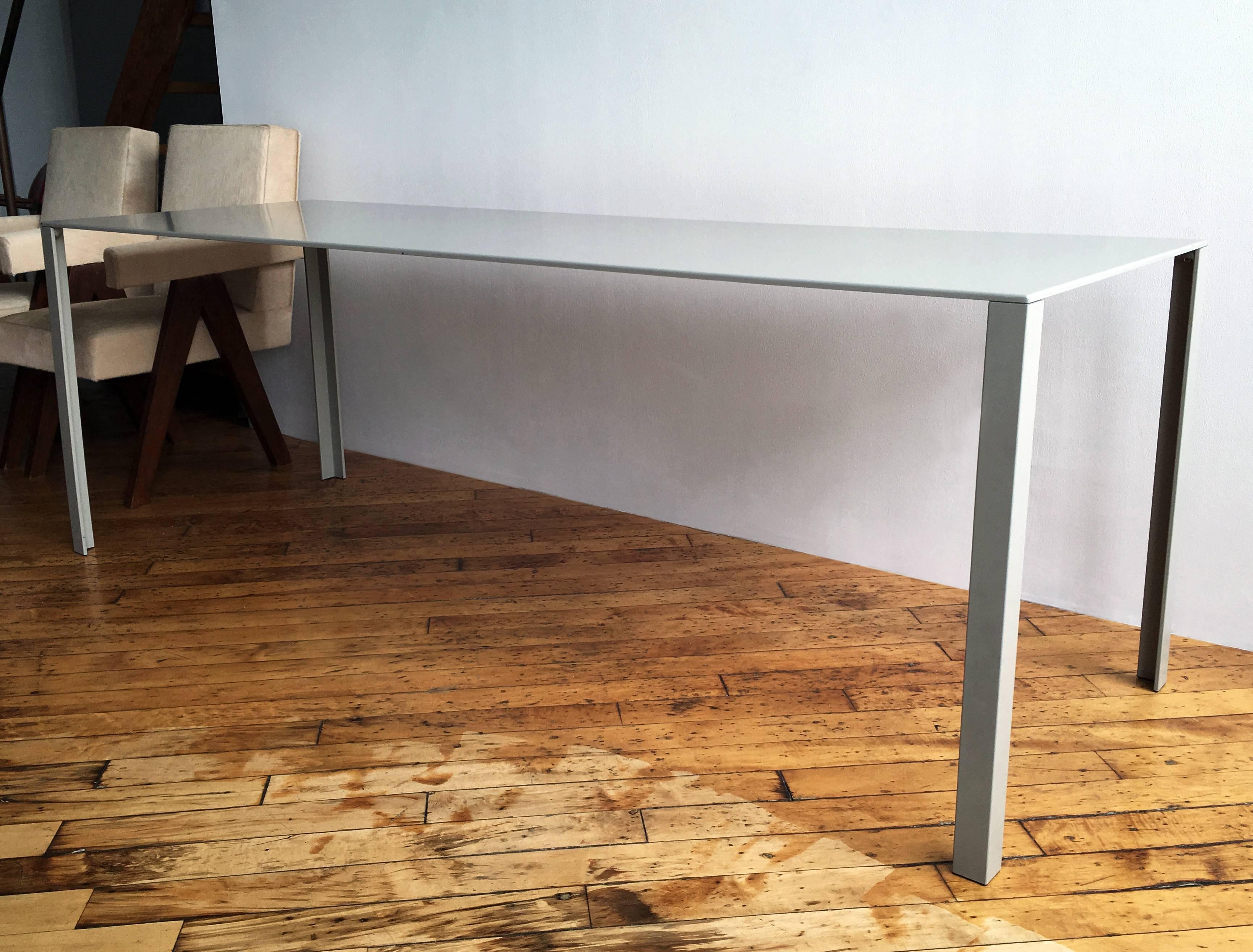 Exemple précoce de la table à manger en métal plié et émaillé de Jean Nouvel. Des proportions extra-longues soutenues par une structure cachée sous le plateau de la table. Patine légère. Fabriqué par Unifor 
 