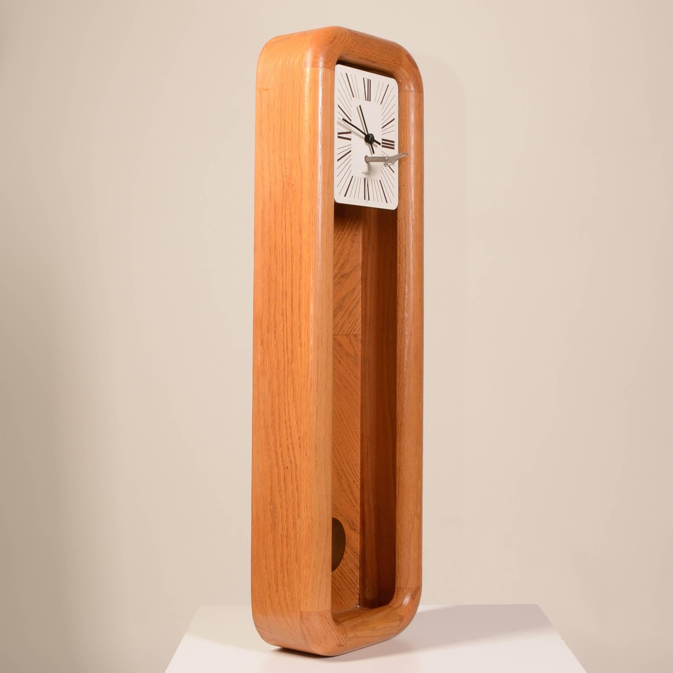 Il s'agit d'une horloge murale à pendule mécanique Howard Miller en chêne massif, datant de 1975. Il s'agit d'un modèle 612, avec un remontoir de 8 jours et une excellente tenue de l'heure. Le boîtier est un beau et lourd chêne luisant et les
