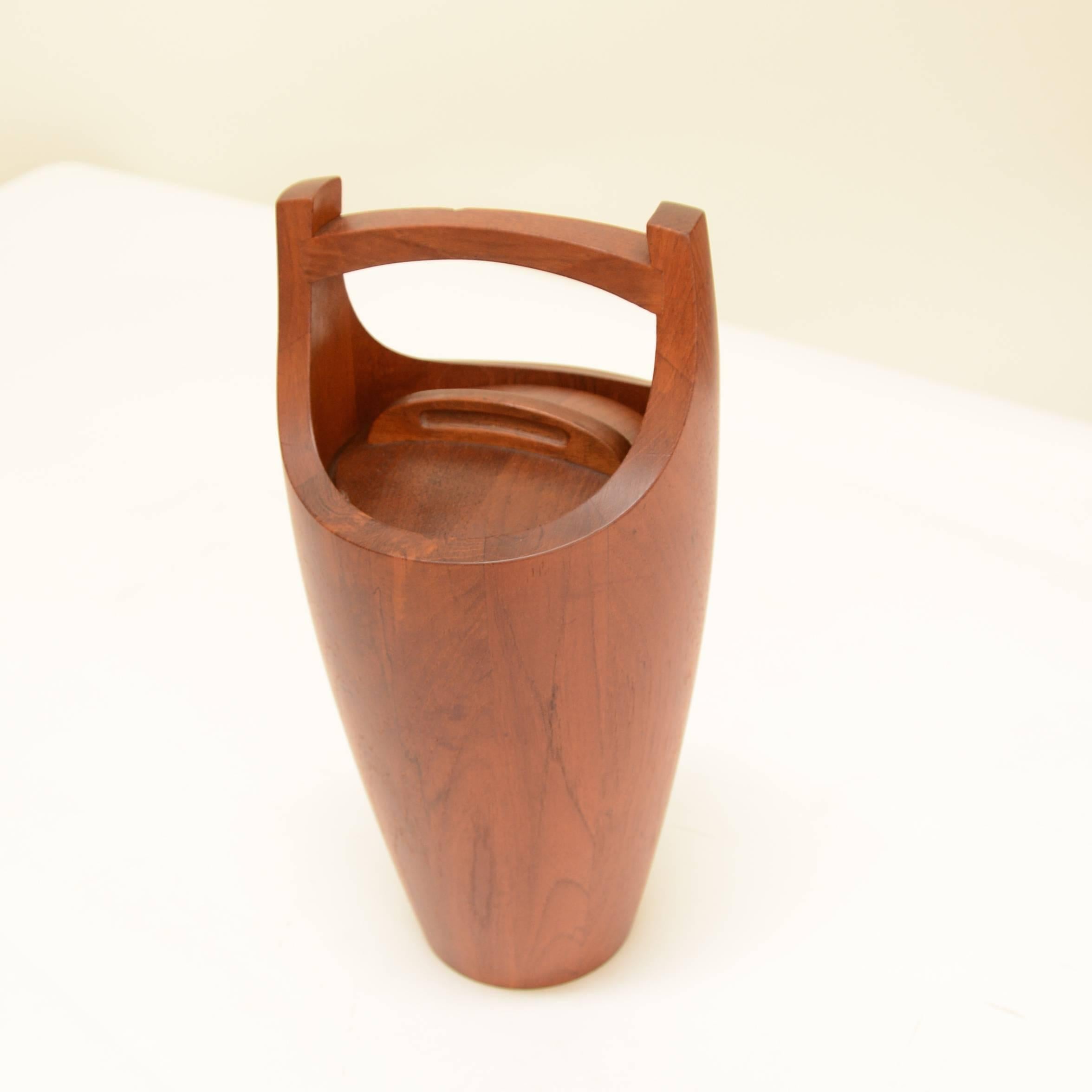 Stunning vintage Danish modern teak "Congo" ice bucket designed by Jens Quistgaard for Dansk. Lined with orange plastic, it's ready for use. 
 
Great condition for its age, with minimal normal wear. There is no separation of the wood and