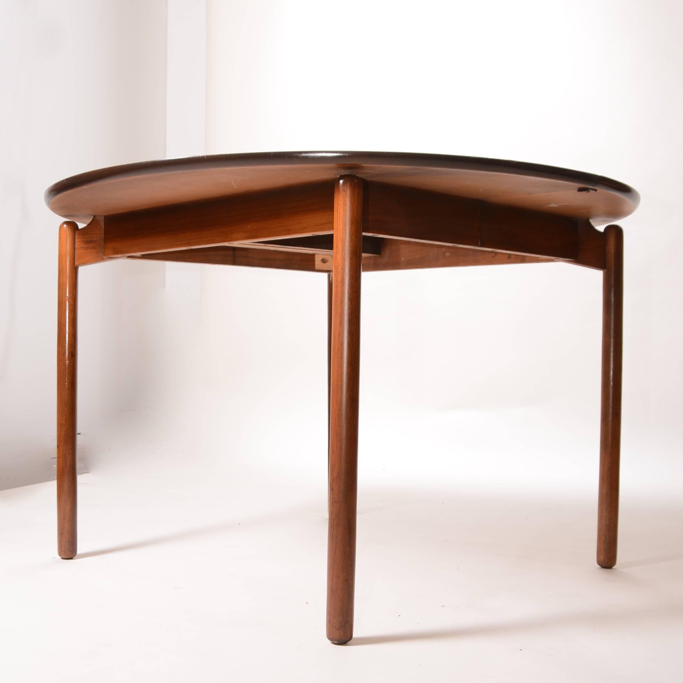 Greta Grossman round walnut dining table by Grossman for Glenn of California. This table has two leaves. Also shown and sold separately are four matching dining chairs by Grossman. Professional re-finishing is available, please inquire for details.