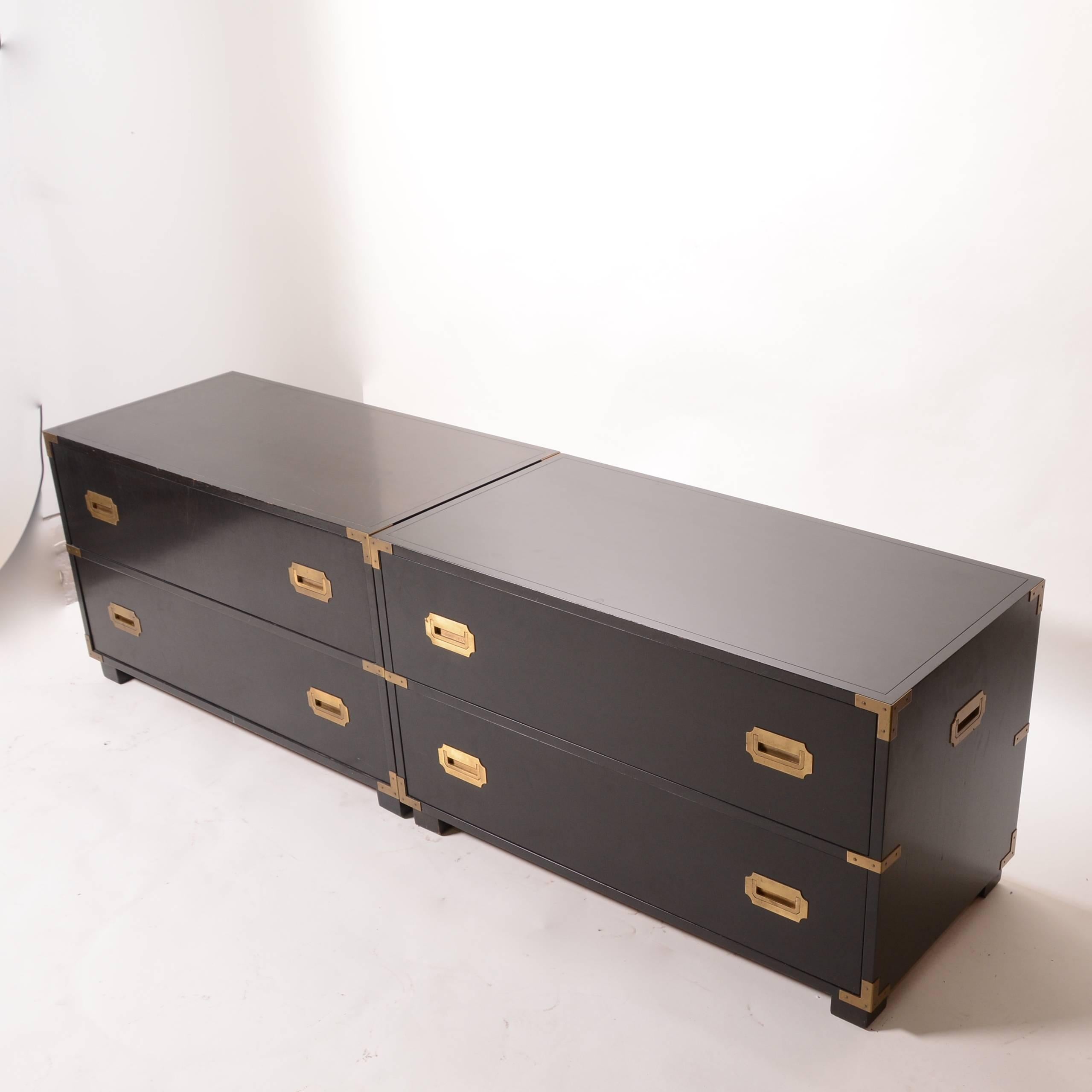 Handsome pair of ebonized Baker Campaign style two-drawer dressers cabinets with brass hardware. Marked. Price is per cabinet.