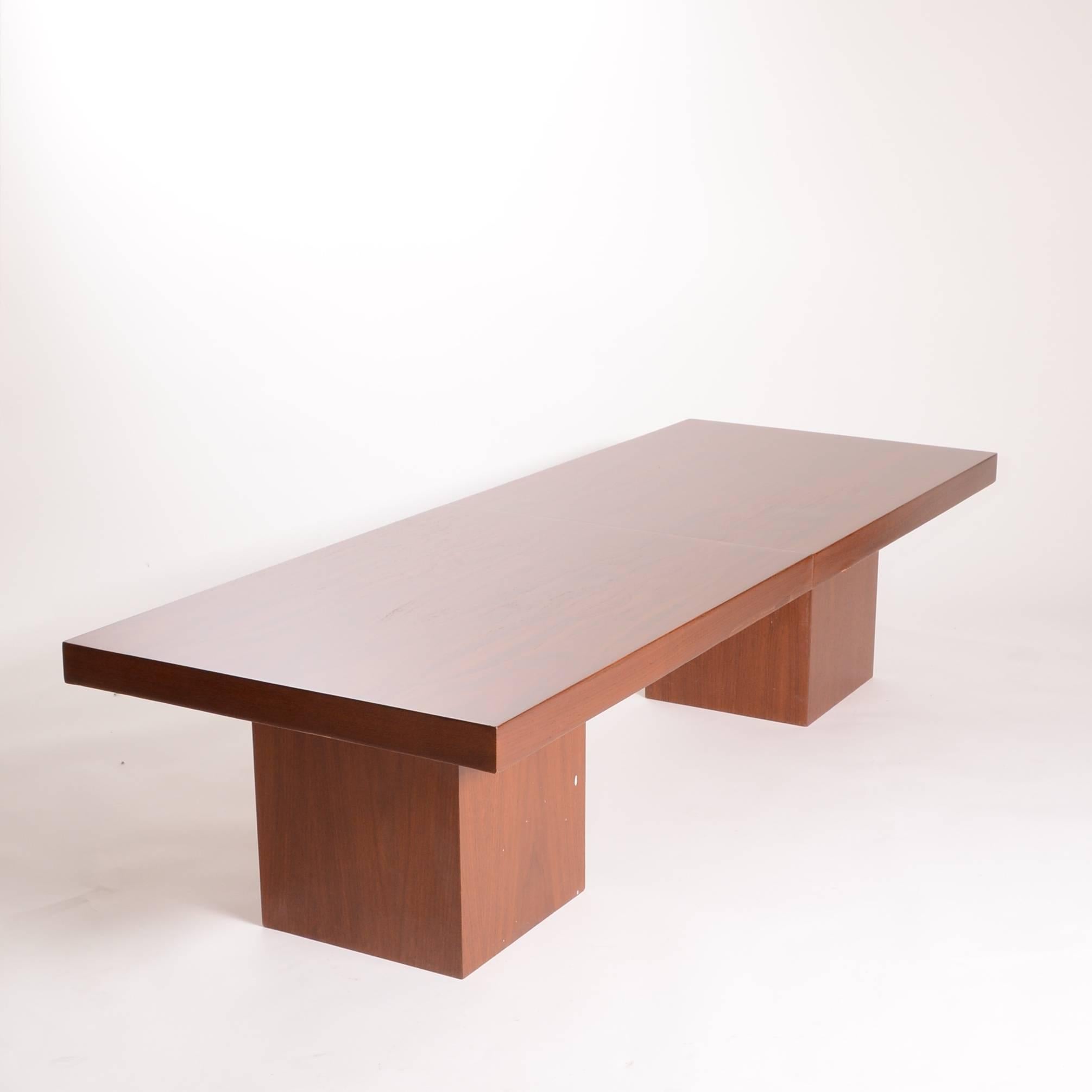 This expanding coffee table by John Keal is both handsome and versatile. When closed the rectilinear top sits on a pair of cube bases for a simple and elegant look. The top separates and expands to reveal a center section of black formica.
This