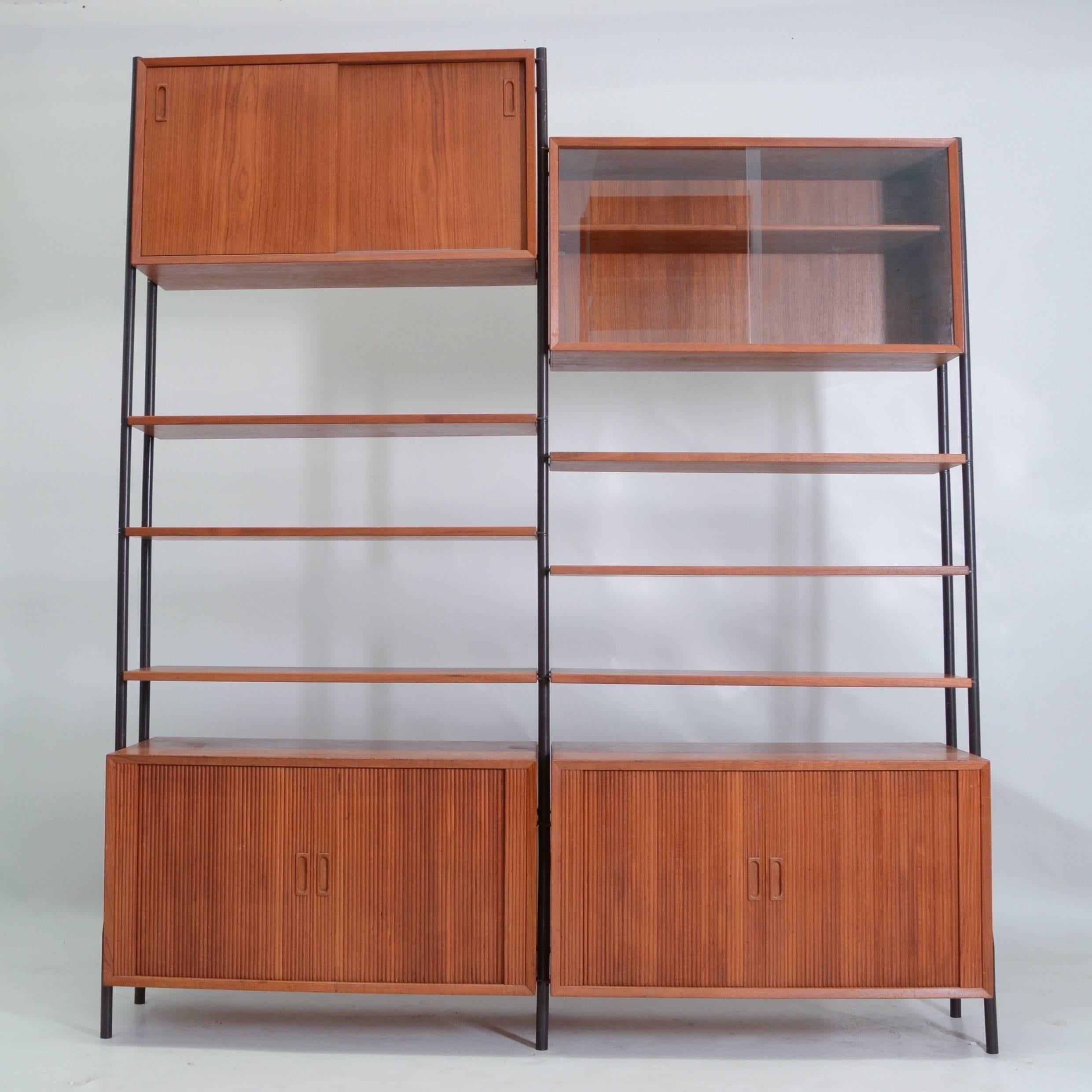 This is a beautiful freestanding teak and steel wall unit by Lyby Mobler of Denmark. This unit features two tambour doored cabinets, one sliding glass door cabinet, one sliding wood door cabinet, multiple shelves and extra corner shelves not