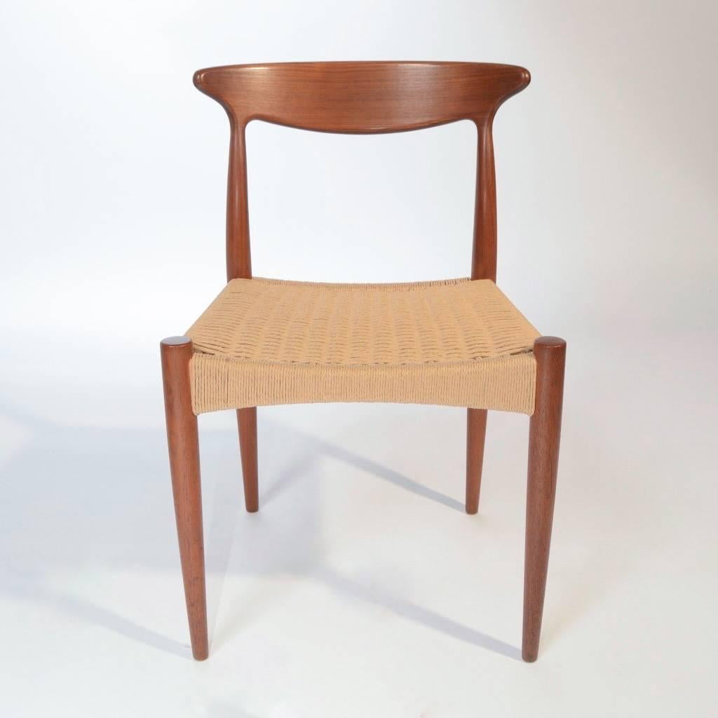 Designed by Arne Hovmand Olsen for Mogens Kold, this gorgeous set of four Danish modern dining chairs have been fully restored including new paper rope seats and refinished teak. Each chair features a curved teak backrest. In showroom condition.
