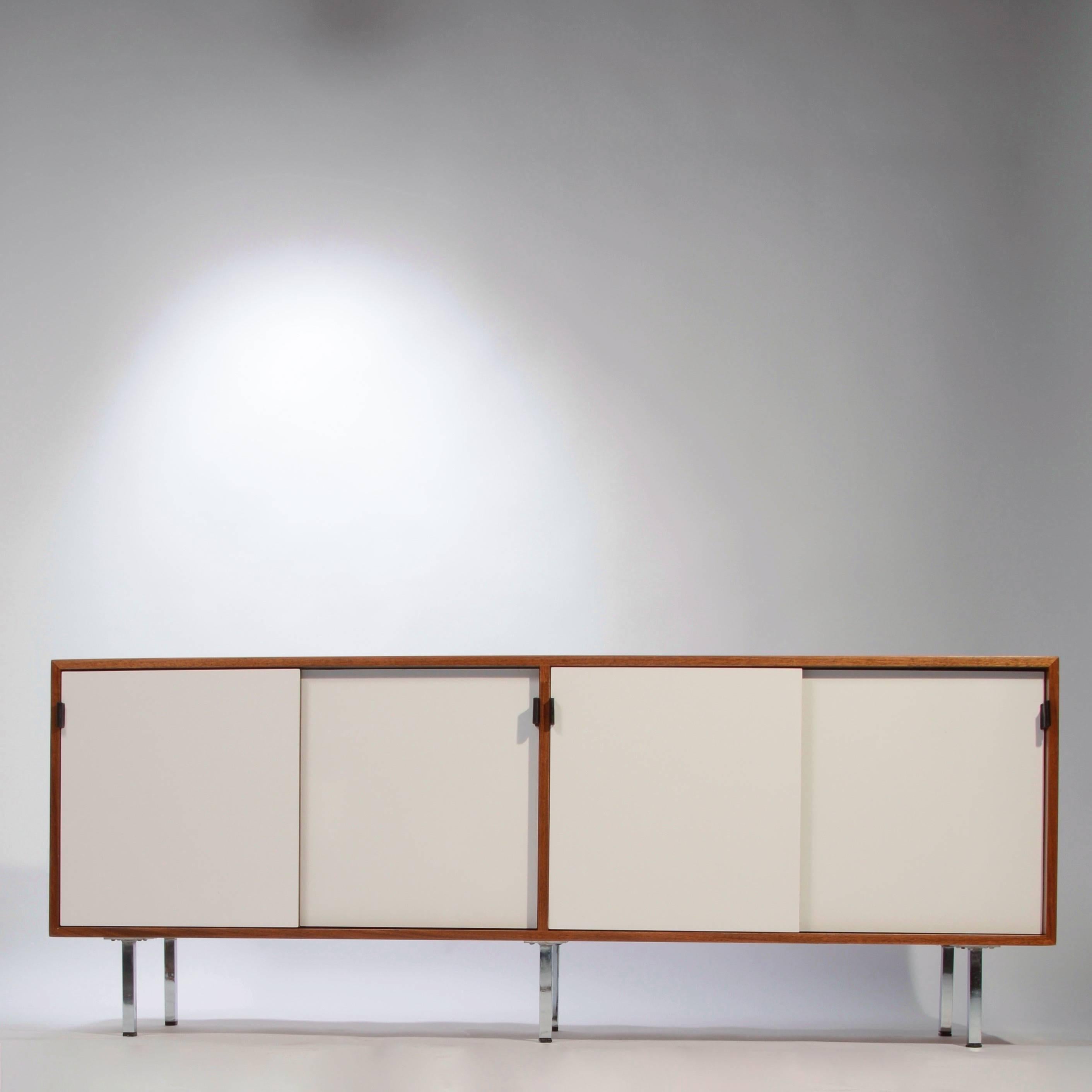This is a fully restored early Florence Knoll credenza featuring new white Formica sliding doors, new professional lacquer finish, leather pulls, chrome legs and solid oak drawers. We have ten in stock and can offer a range of interior options such