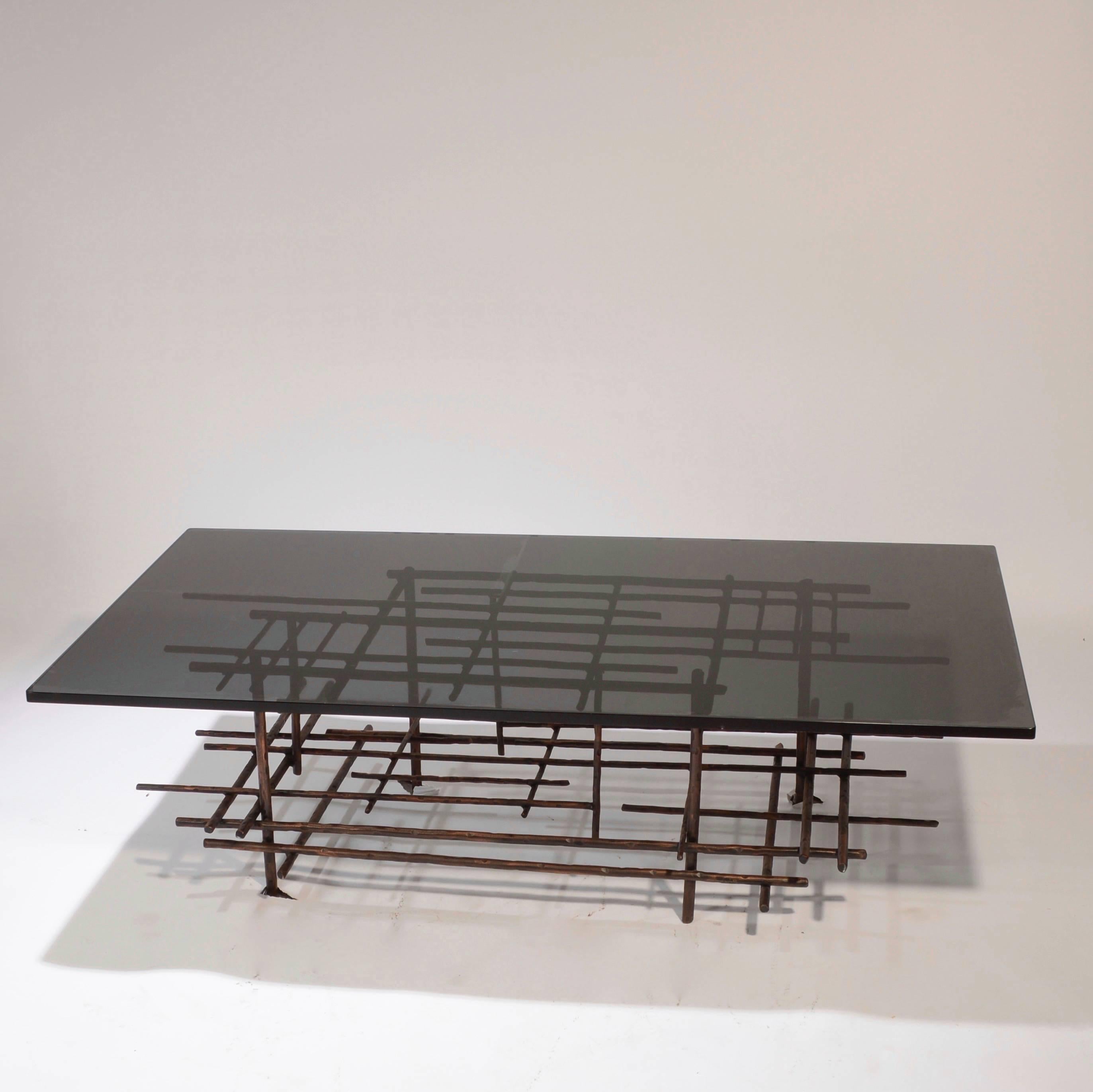 This is an amazing modern sculpture coffee table made from solid steel and thick, smoked glass.