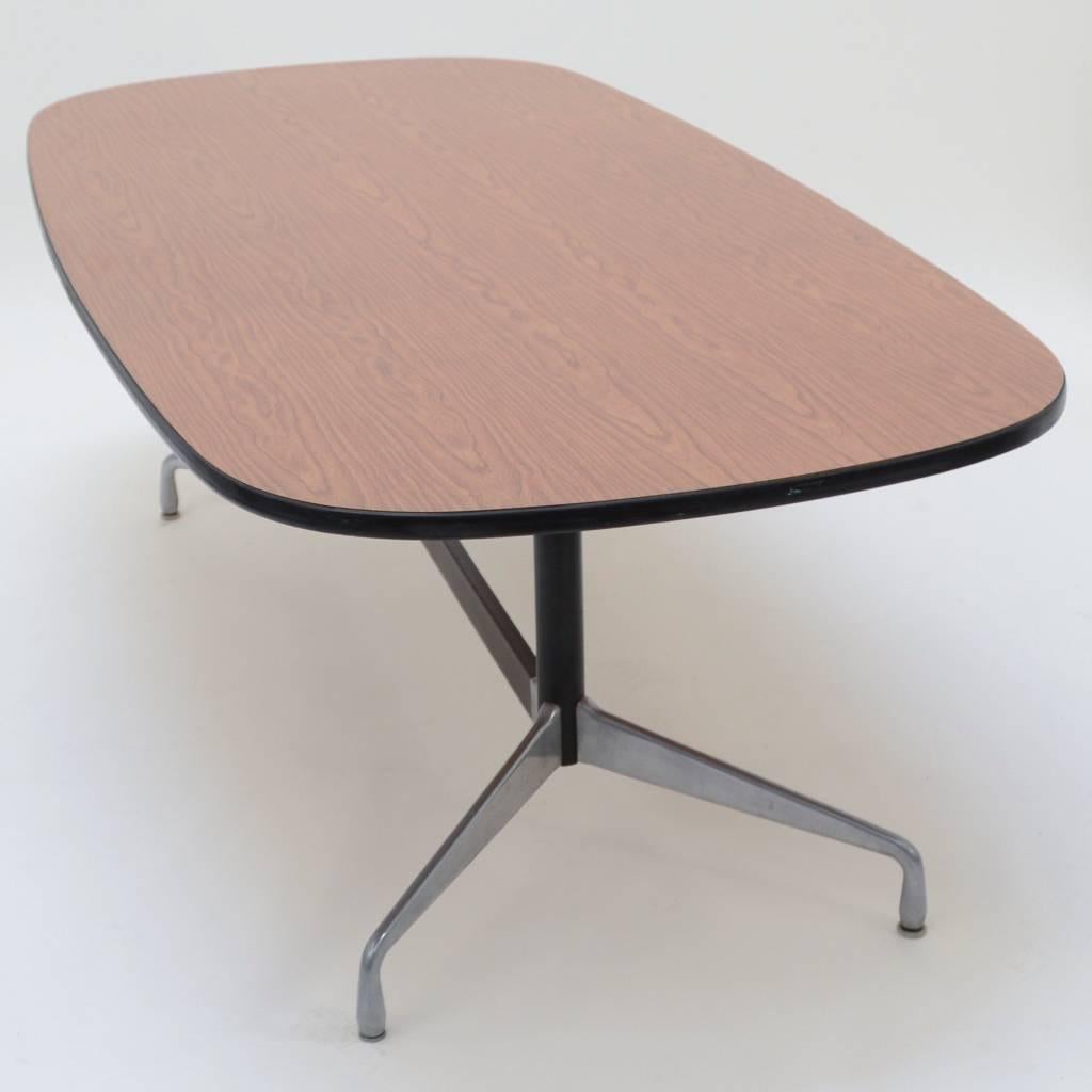 This is a racetrack shaped dining table designed by Charles and Ray Eames for Herman Miller. The tabletop is resting on the standard Eames segmented aluminum base.