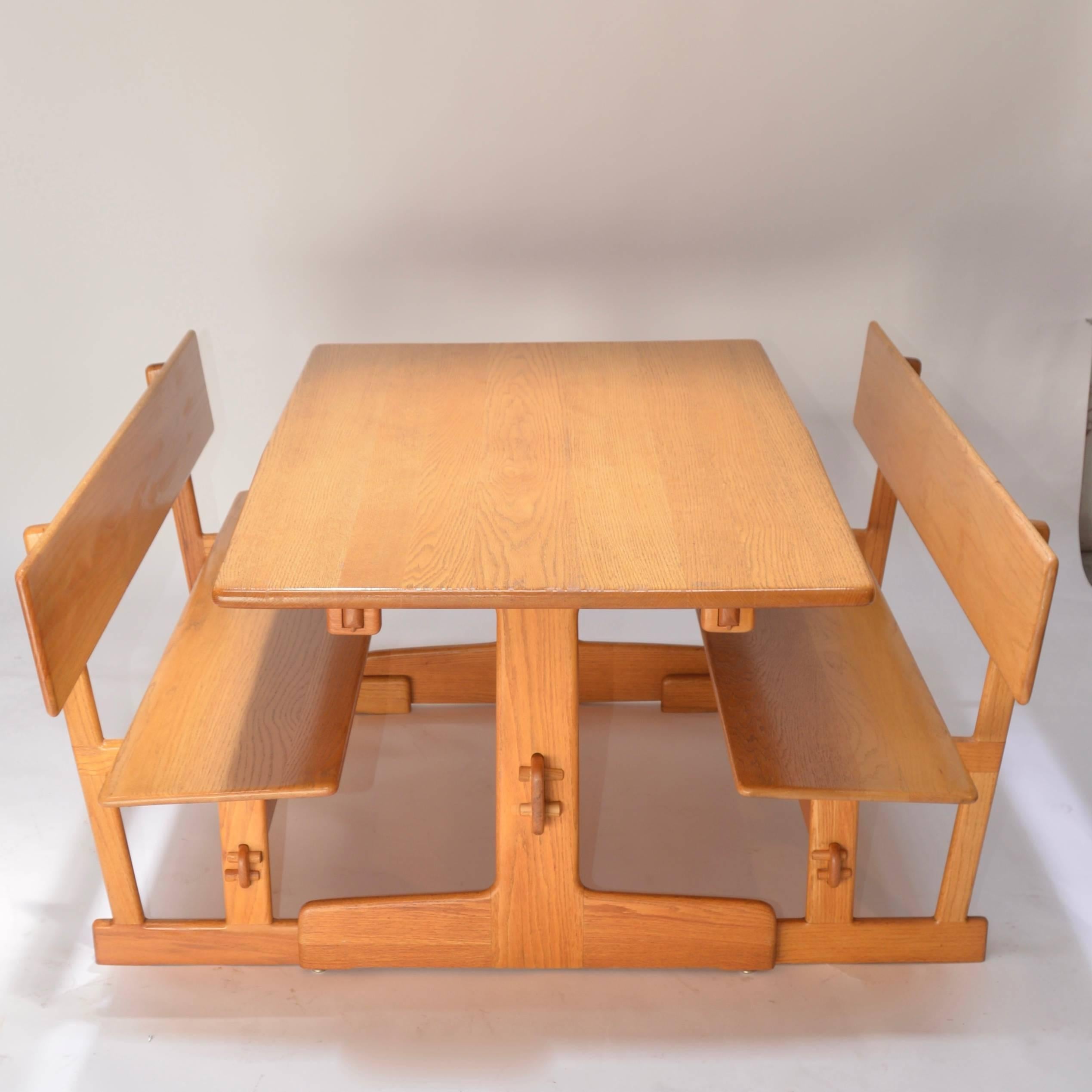 This is a beautiful trestle dining table with matching benches by Gerald McCabe for Orange Crate Modern. This table retains its original finish over solid oak.