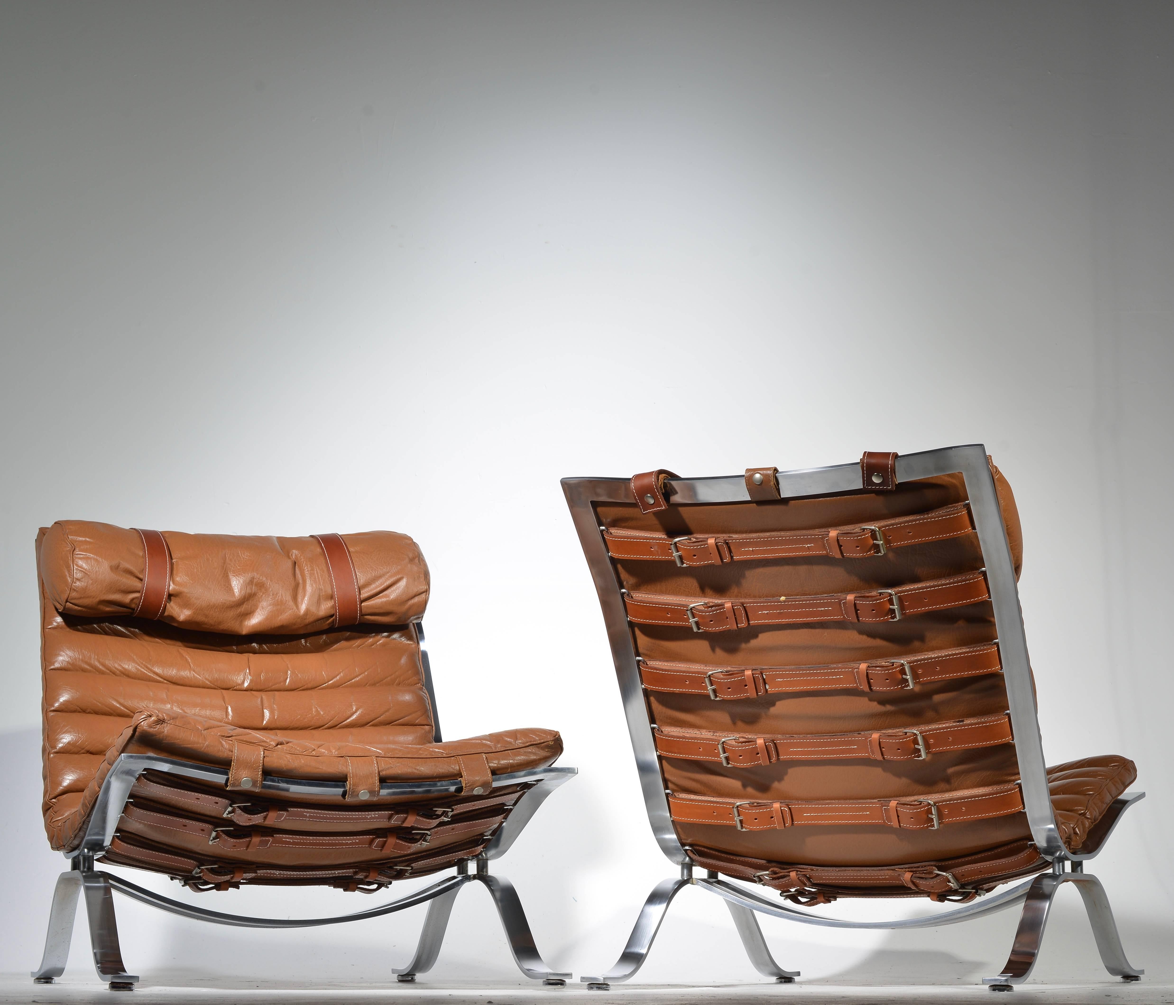 An amazing pair of Ari chairs designed in 1966, by Arne Norell. Produced by Arne Norell AB in Aneby, Sweden. The strapping has been professionally replaced.