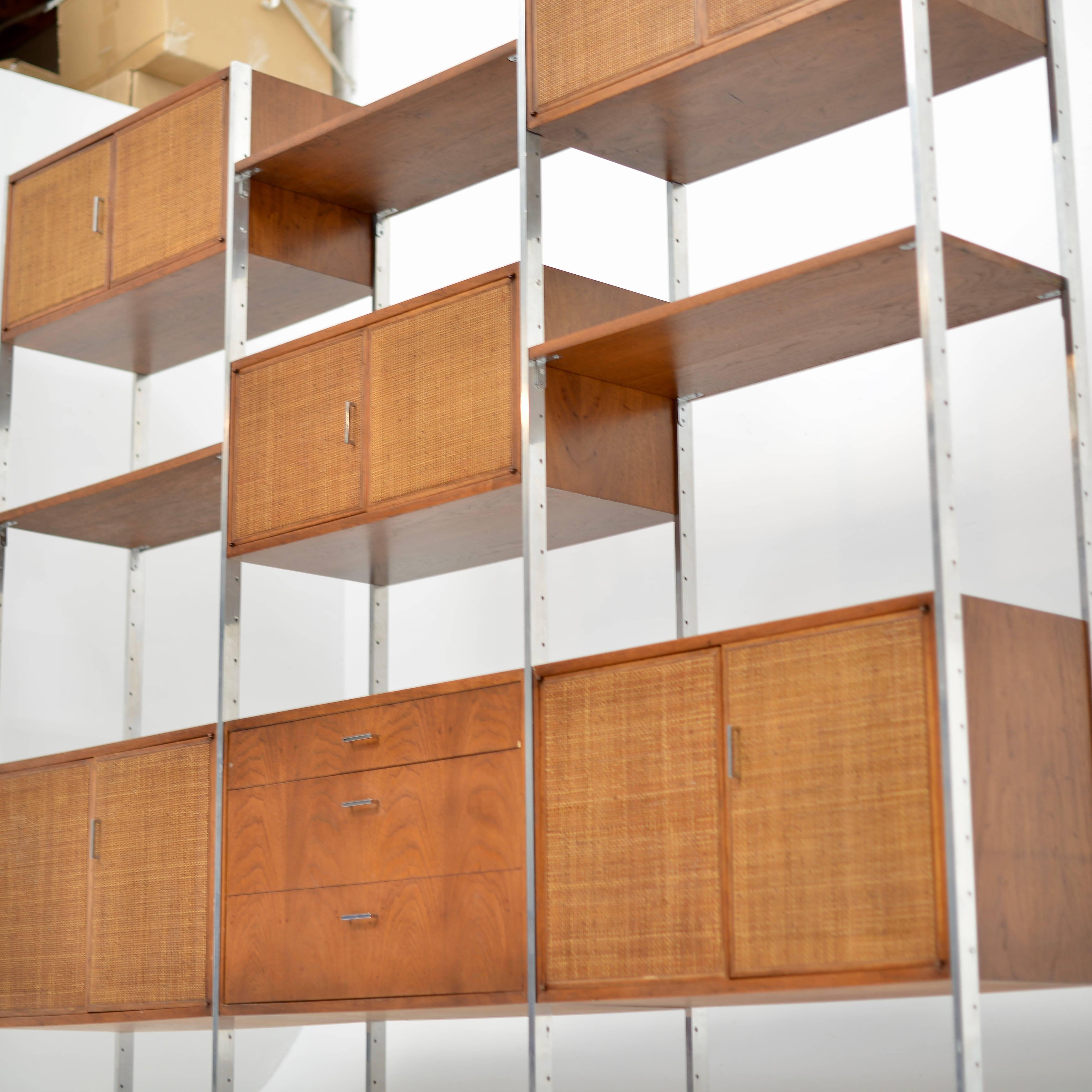 This is a stunning modern wall unit by Founders, a Division of Knoll International, attributed to Milo Baughman.
Aluminium supports with walnut shelves, cabinets and drawers, with woven cane doors.
