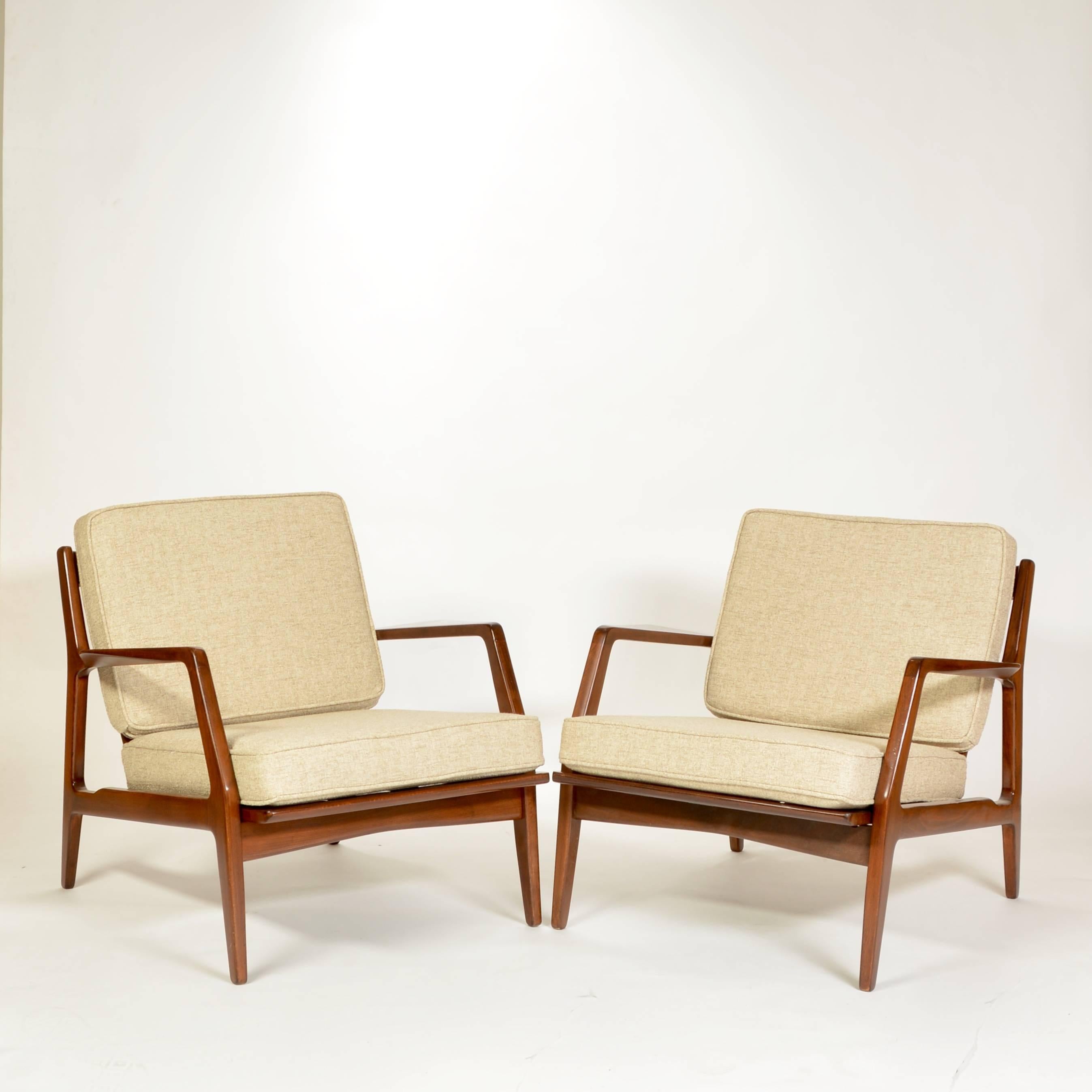 This is a pair of fully restored lounge chairs by  Ib Kofod-Larsen.  This set has been refinished in walnut lacquer, re-webbed and new cushions/upholstery.  Price is for the pair.  
Located at our East Hollywood showroom.  