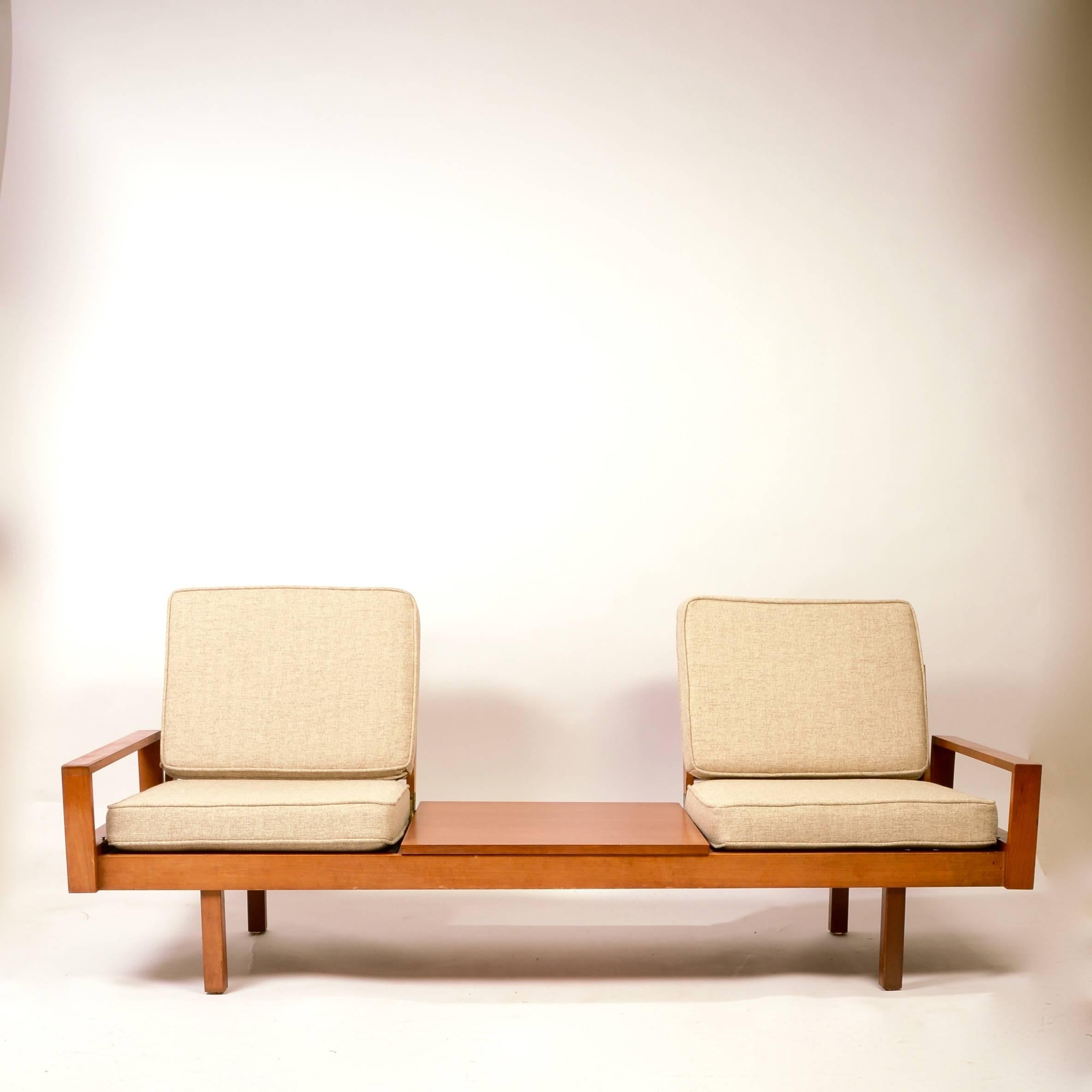 This sofa is part of a modular set by Martin Borenstein for Brown & Saltman. The seats, armrests and walnut tables of this system can be rearranged to any number of ways.  We are selling this set which includes 2 3-bay units, 2 2-bay units, and a