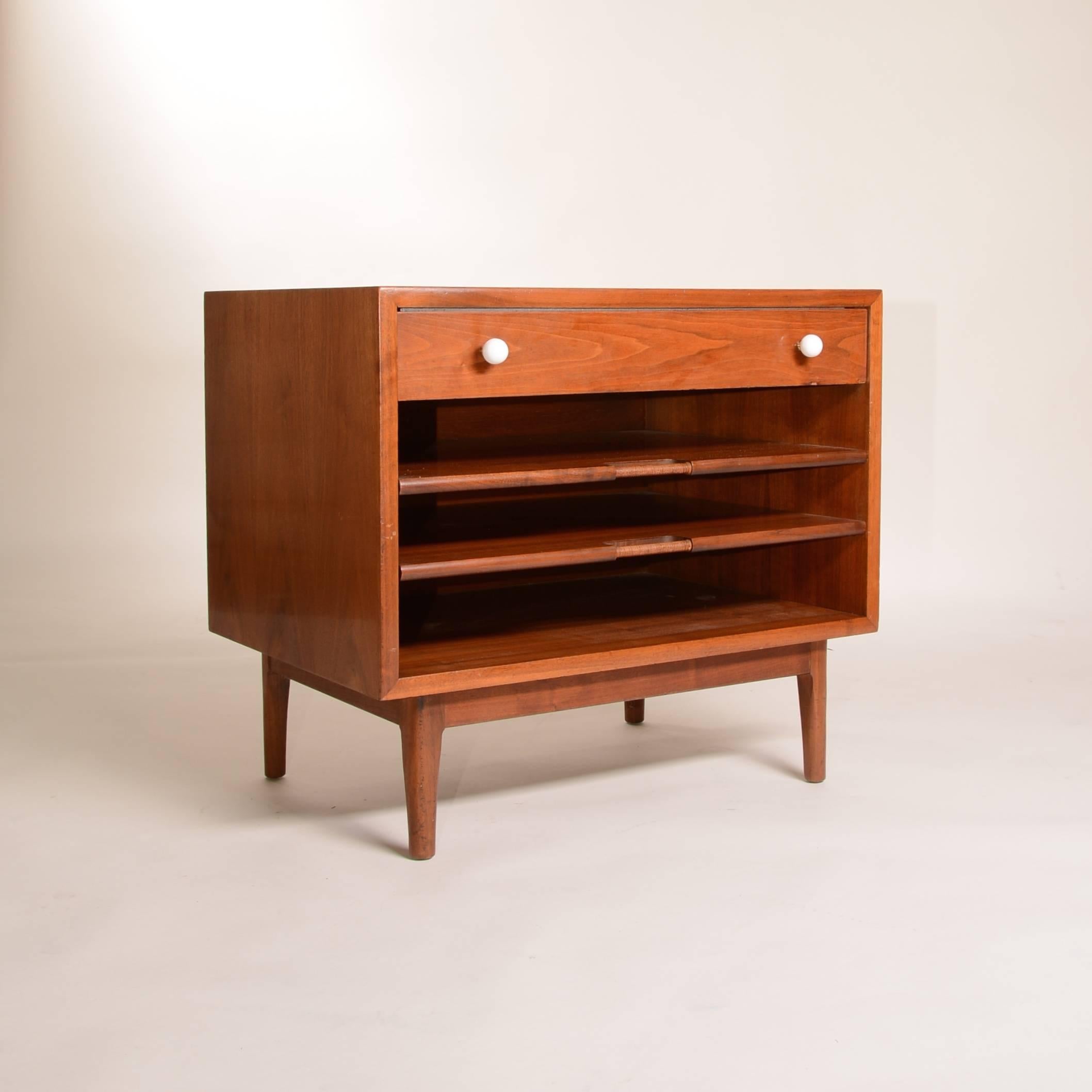A gorgeous walnut side table designed by Kipp Stewart for Drexel. It features pull out shelves, perfect for magazines, newspapers and books, and an upper drawer. Works beautiful as a nightstand, or as a clever accent in your living room.