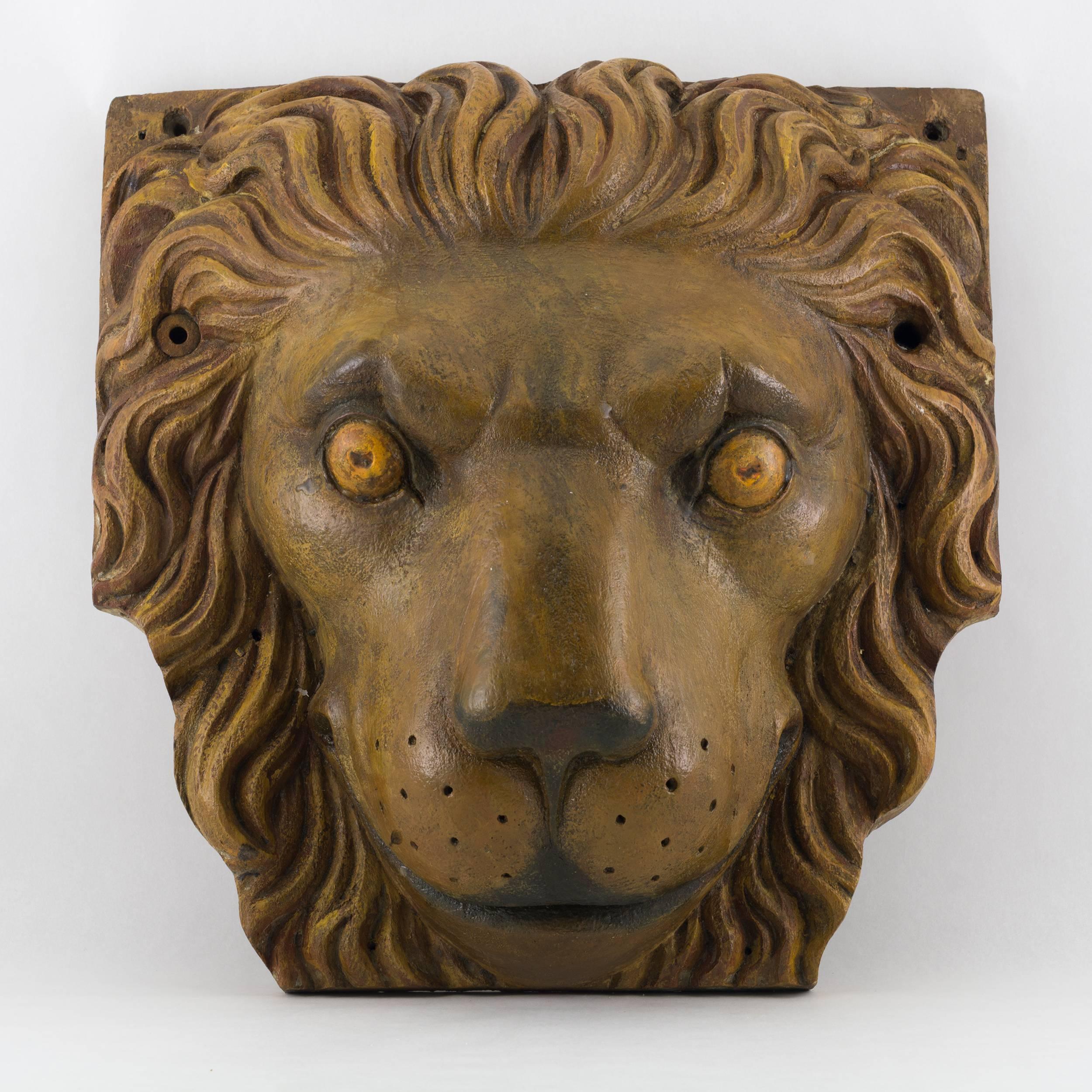 Pair of carved and painted ship’s cathead terminals in the form of a lion’s face. A cathead is a large beam located on either bow of a sailing ship and angled outward at about 45 degrees. The beam supports the ship's anchor when raising or lowering