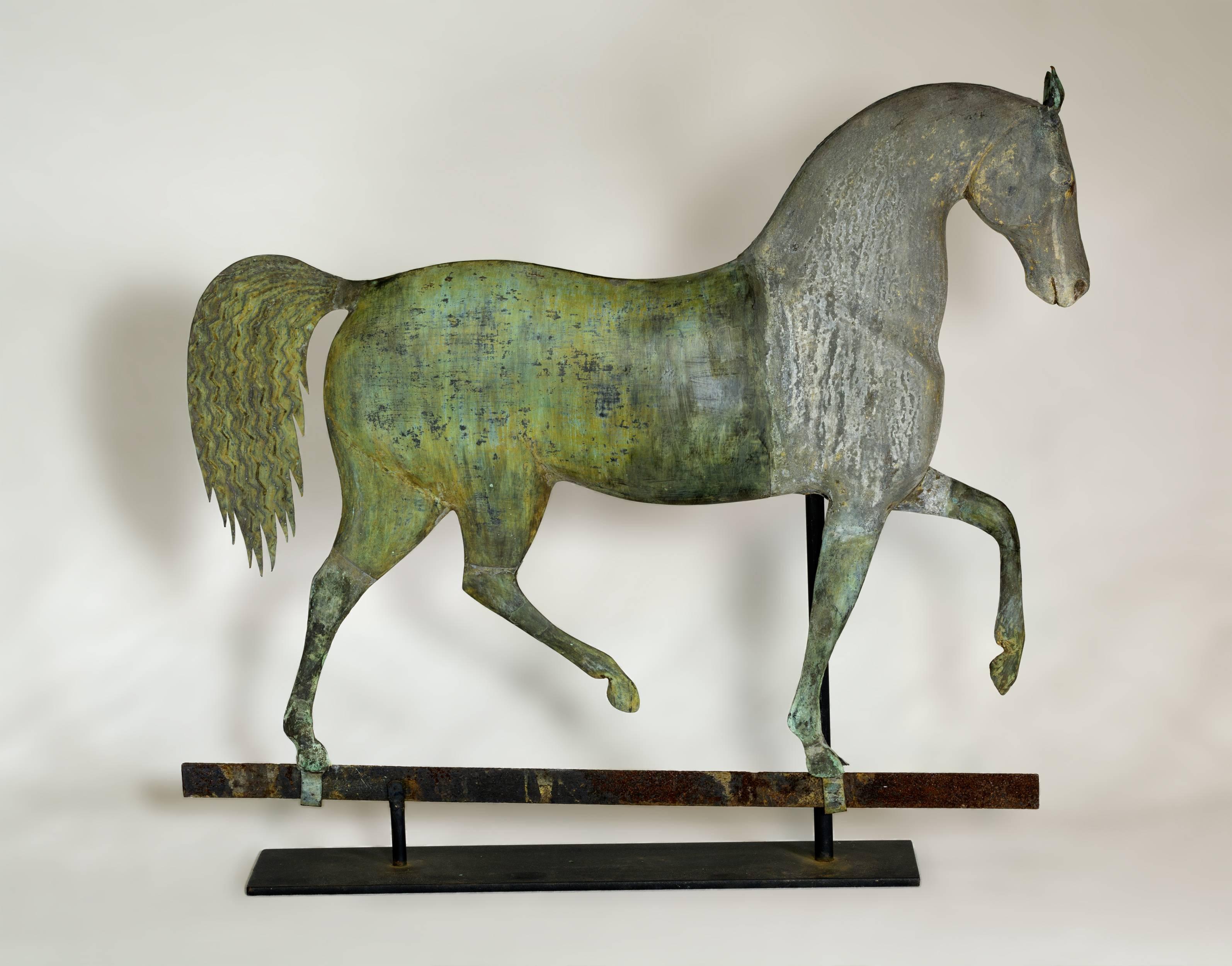 The body is made of casted zinc with molded hollow copper mid and hind sections with applied copper ears, mane and unusual waffle style corrugated tail. Sits on its original strap base. Original condition with strong verdigris and weathered gilt.