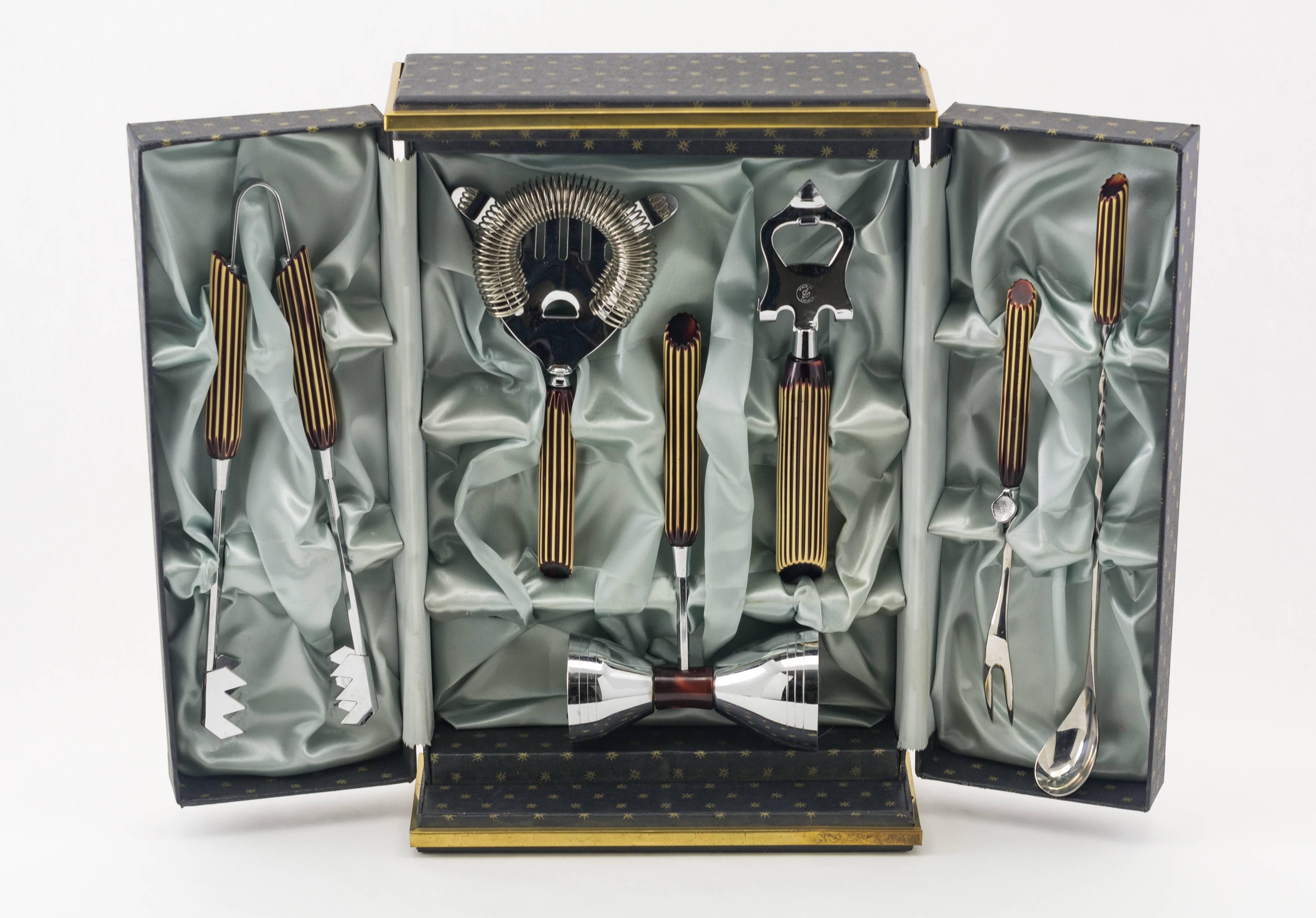 Vintage Glo-Hill six-piece bartool set, each chrome piece with
ivory cut to translucent red Bakelite handles – all in a lined, fitted
two door armoire-form box with metal details and covered in a star
patterned paper.
Canada, circa