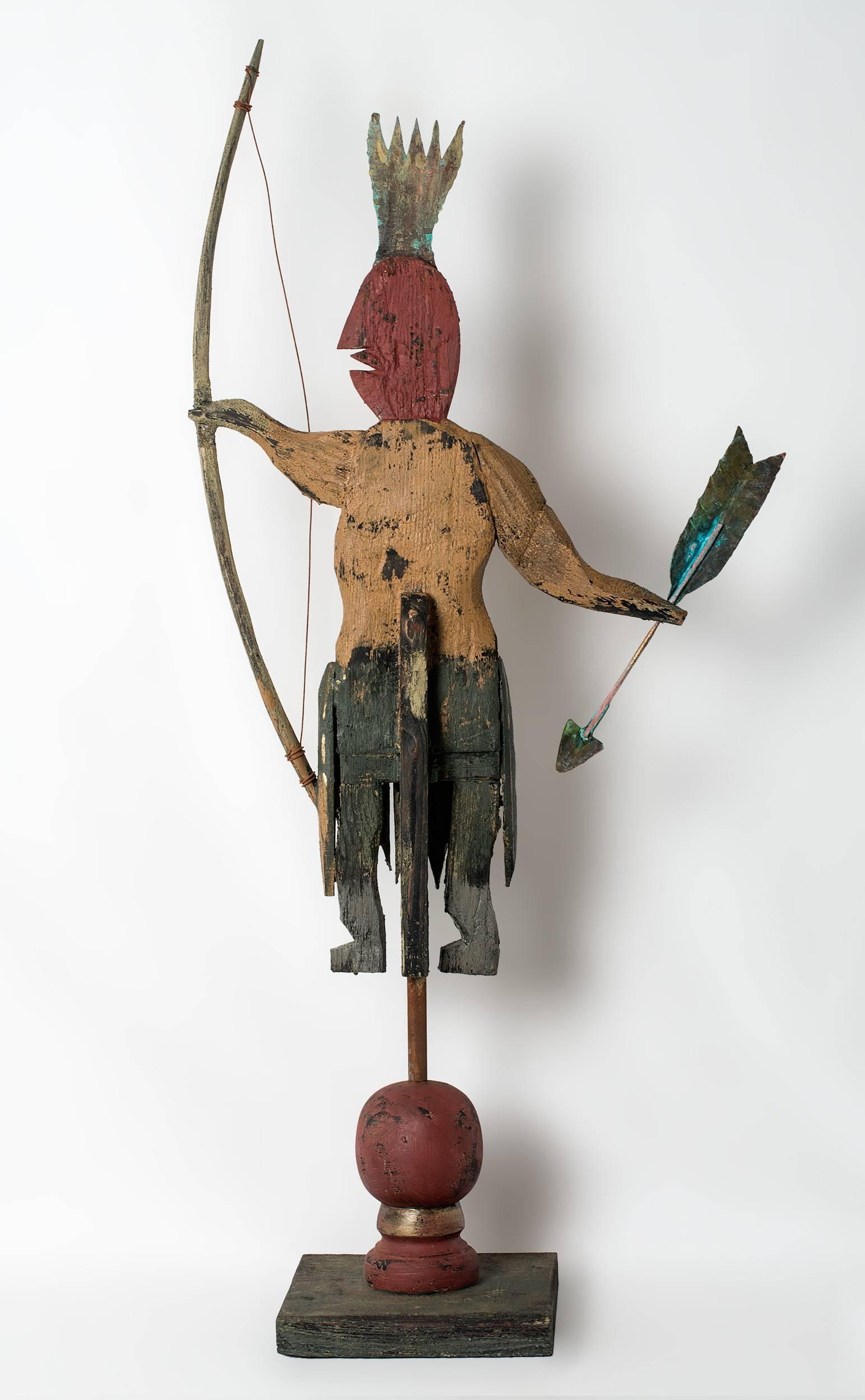 Carved and painted standing Indian with bow and arrow.
Carved out of reclaimed wood and copper and painted with milk paint by Steve Hazlett. One hundred plus year old heart pine salvaged from out buildings and barns built during the 19th century