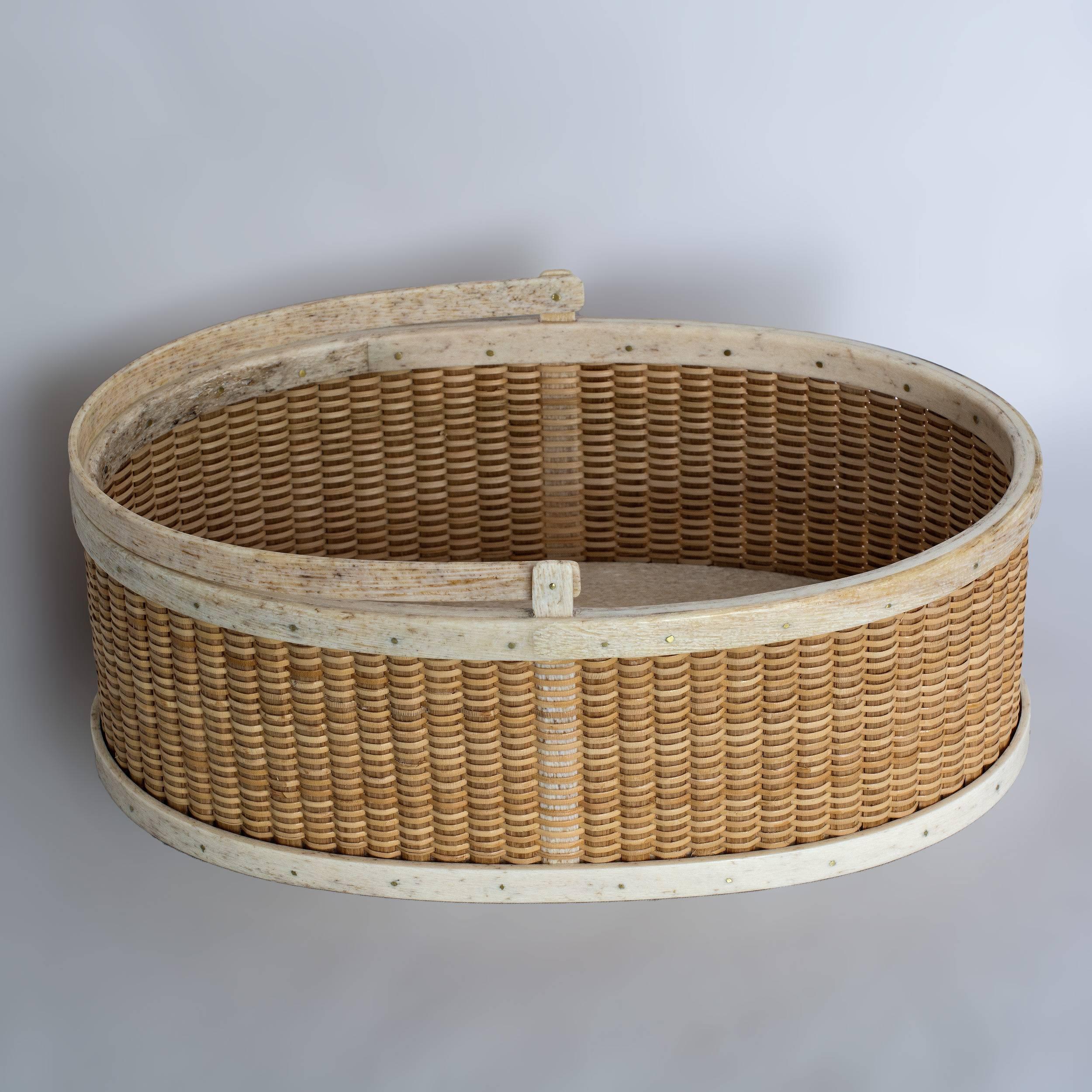 Unusual shallow oval form Nantucket lightship basket with antique bone handle, rims and base with oak staves.
8 ½” x 5 ½” x 3”, 7 ½” to handle crest