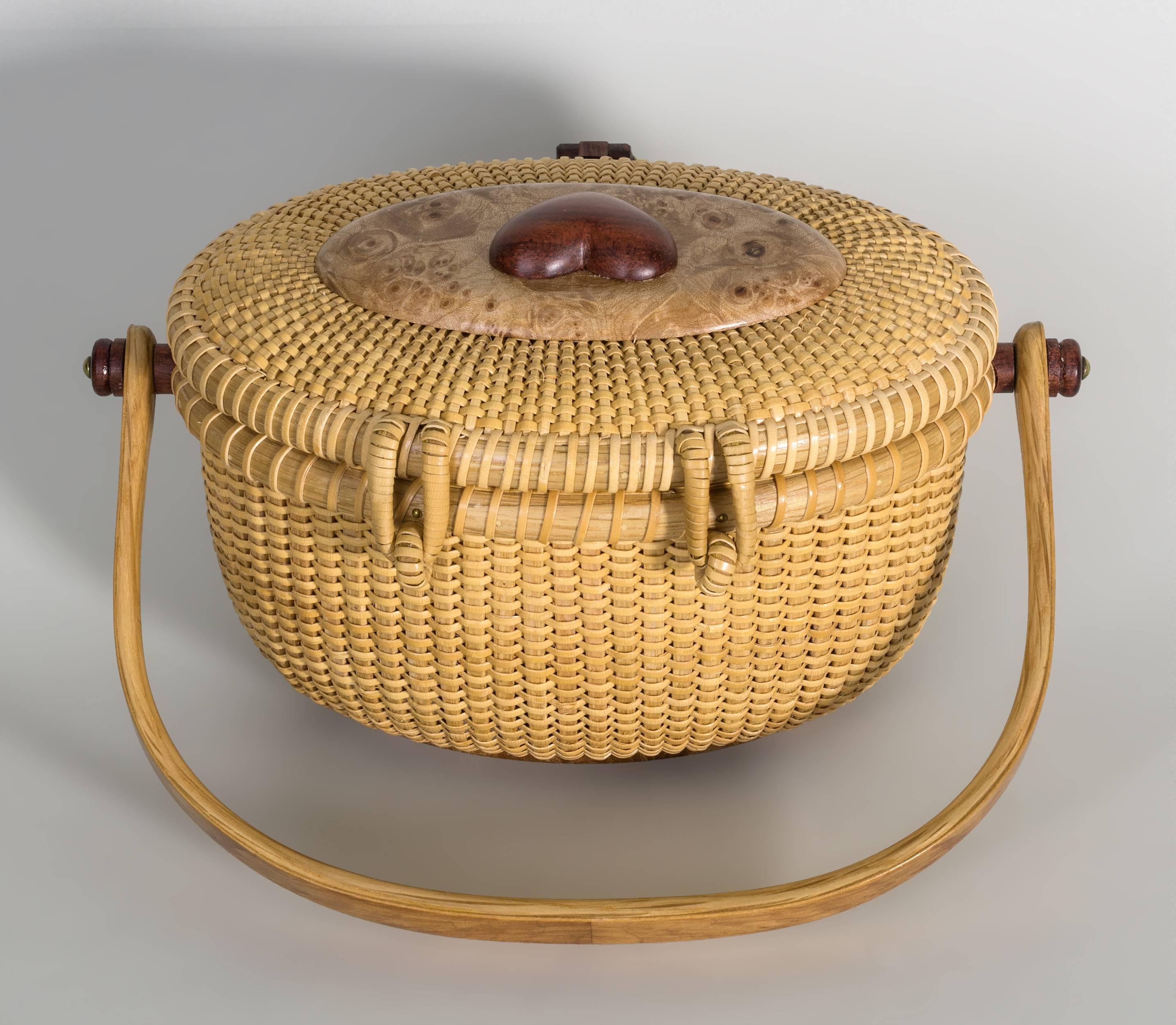 By Nap Plank of Nantucket, one of the top Nantucket Basket artists working contemporarily on the island.  This dainty basket features a burl maple overlaid carved and bent oak swing handle with exotic rosewood knobs, birdseye maple top surmounted by