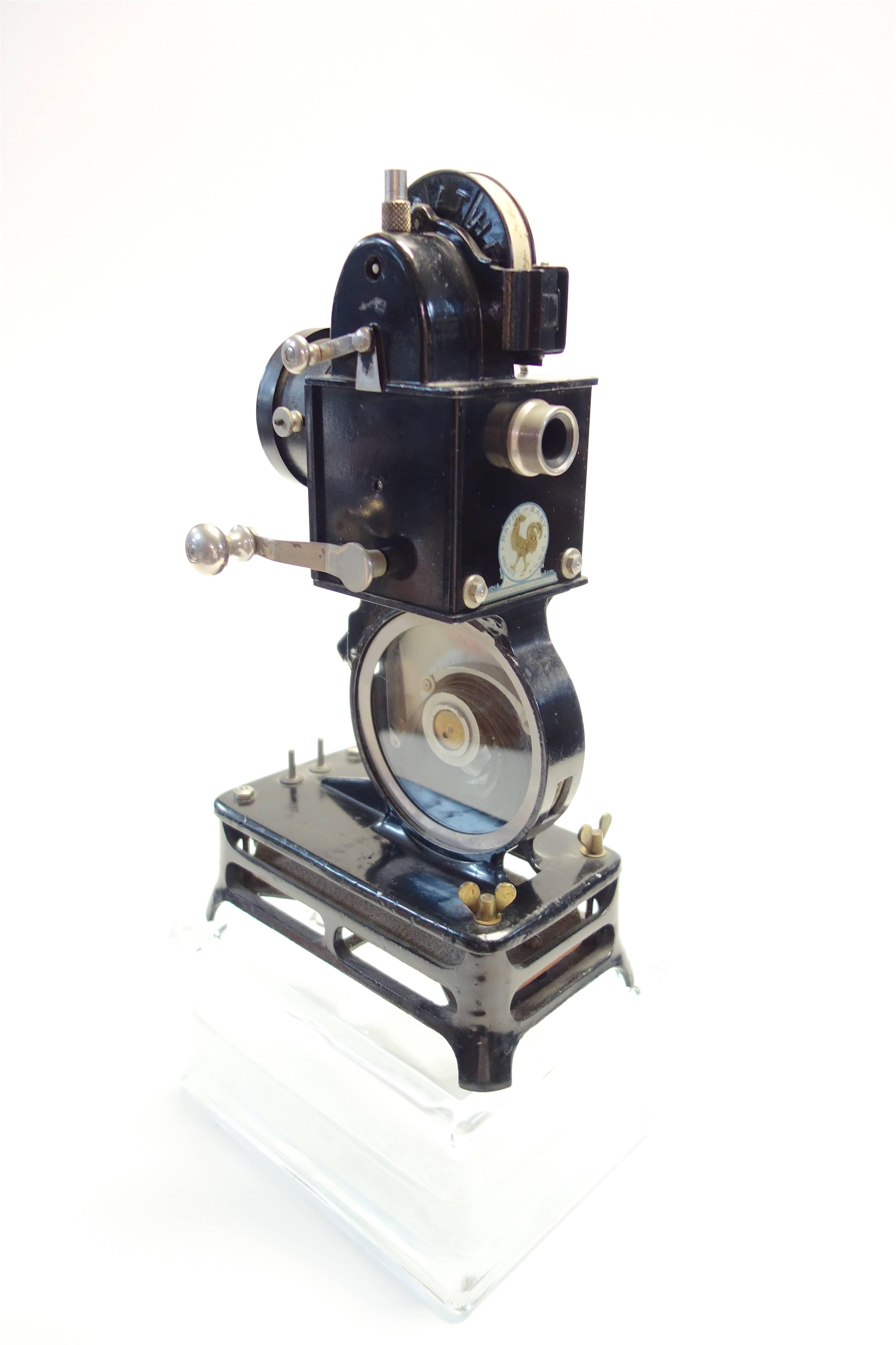 Offered for your approval is this, circa 1922 Pathe Baby hand crank cinema projector. Spectacular original condition and mounted on your choice of a glass or old stone display block.

Sold complete with original labels and an original reel of