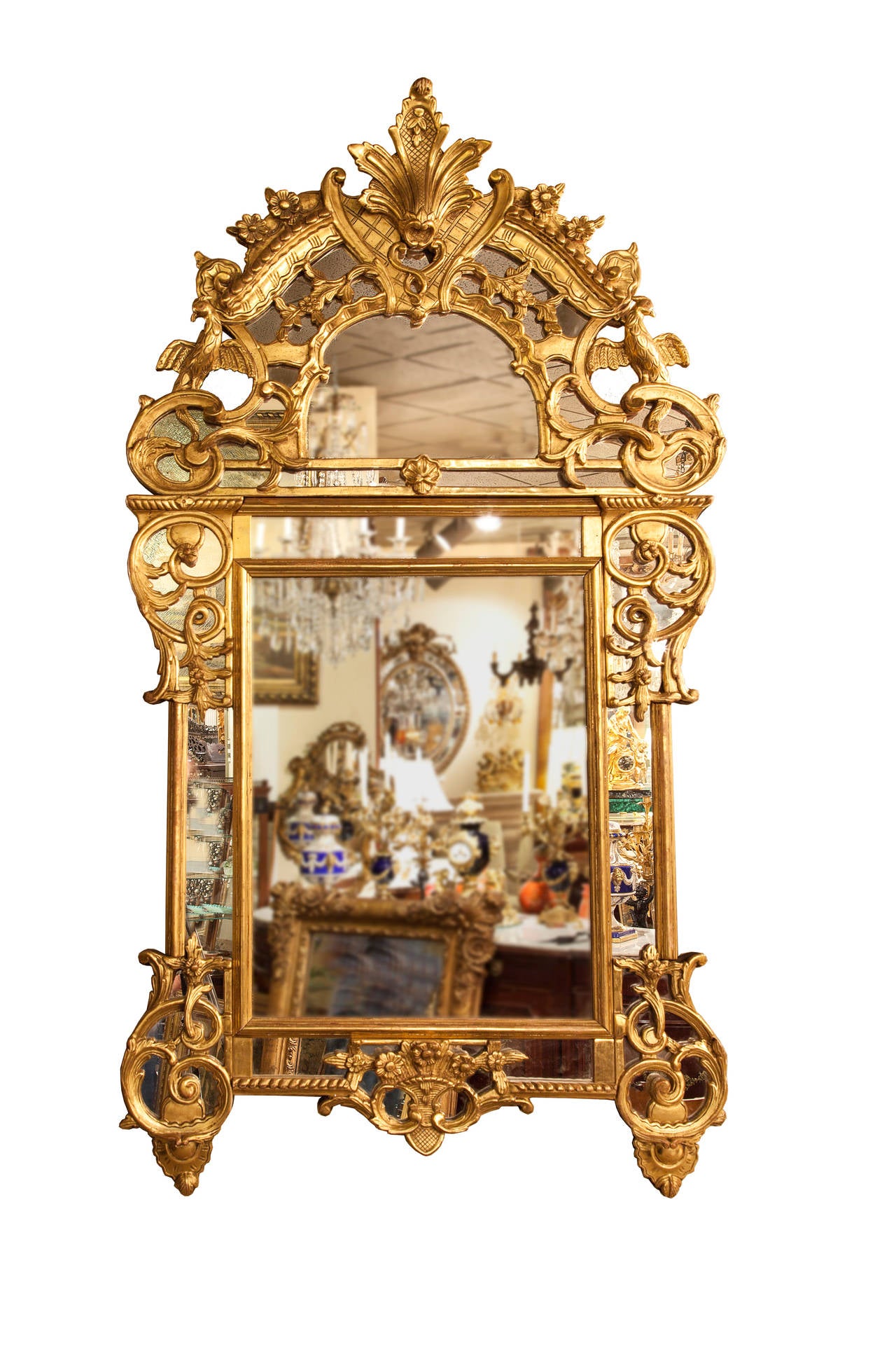 Acanthus plume crest surmounts hand carved, giltwood open work of stylized birds and exuberant scrollwork over original
Mirror plate. The main body of an inner rectangular frame
Supported by four volutes of open giltwood scrollwork overlaid 
On