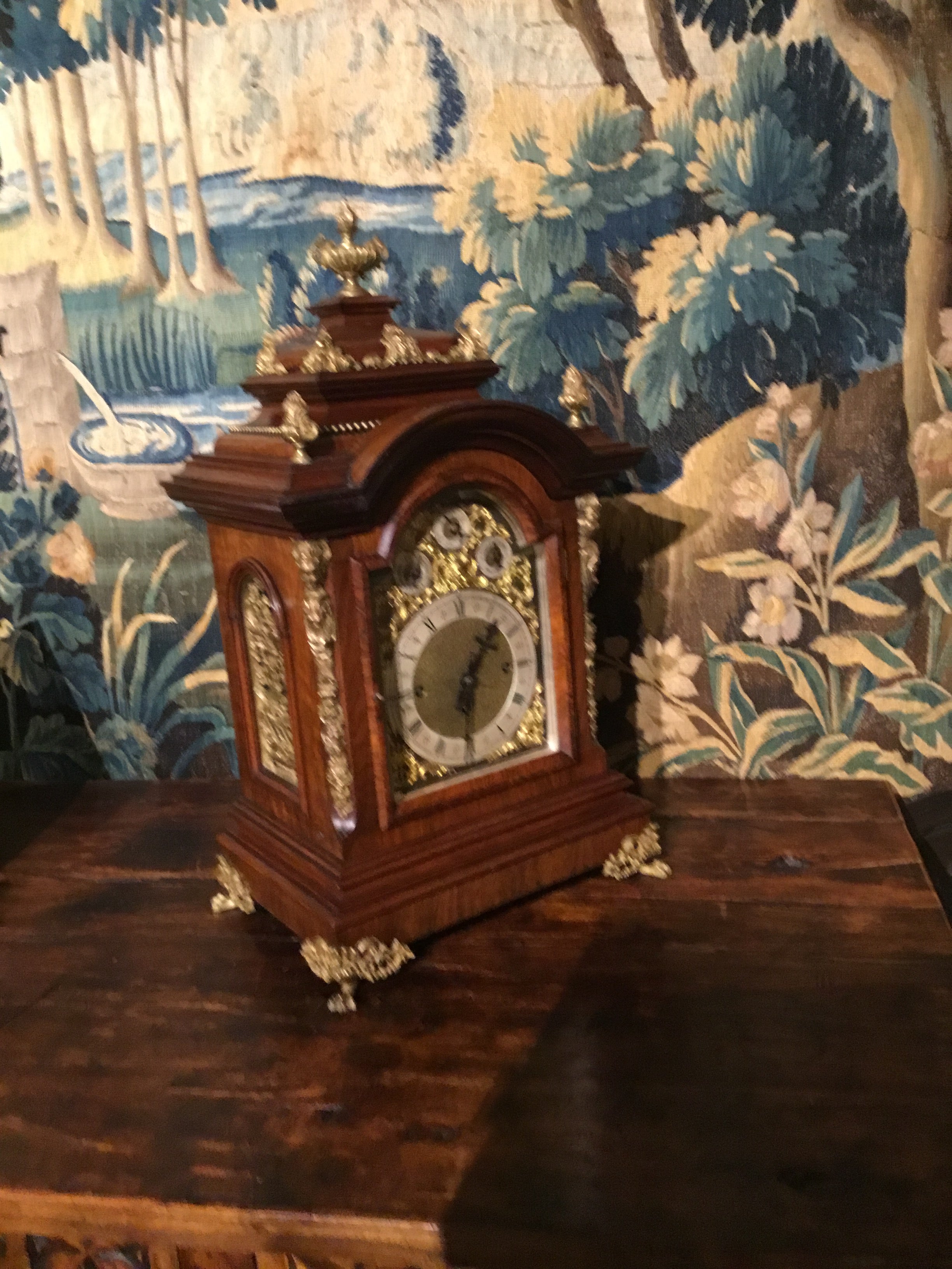 Very handsome walnut clock with ormolu mounts on the sides, front corners and paw feet.
Urn type finials grace the top center and top corners. Beveled glass front opening to a face
With Roman numerals. Has original key and pendulum.