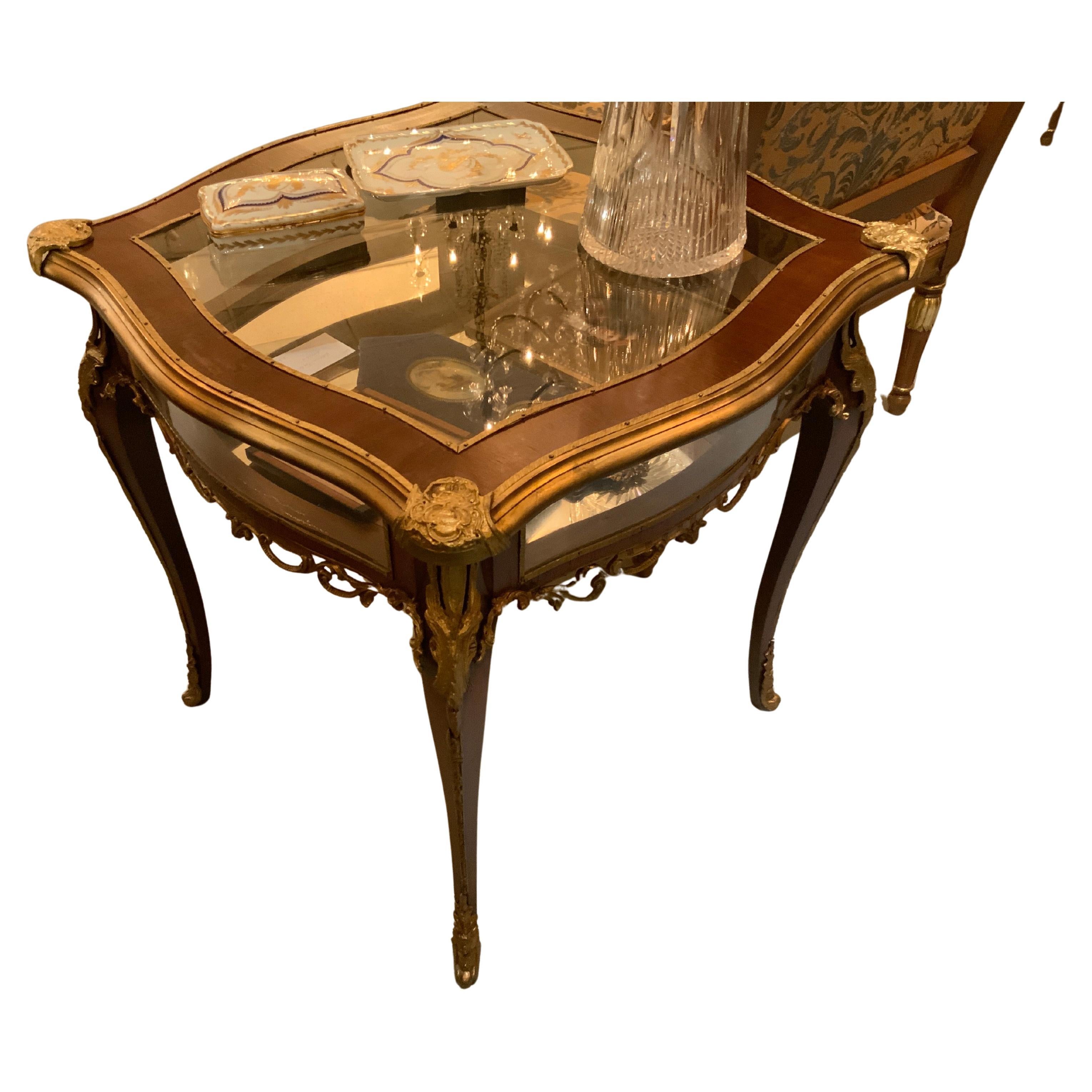 Vitrina/Mesa expositora estilo Luis XV con monturas de bronce dorado y tapa de cristal
