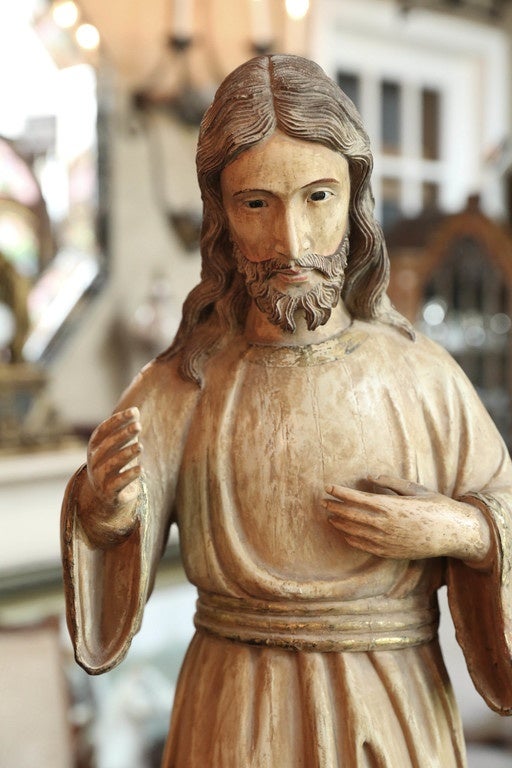 Antique wooden statue of Jesus
Pale gold robe with slight gilded decoration
Stands on a pale green base