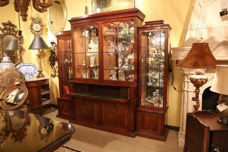 Three section English mahogany breakfront that is 19 th century.
Shelves are glass and are movable to obtain different heights for
Display. The back is mirrored and lights have been added.
It has the lovely old patina in fine condition and has